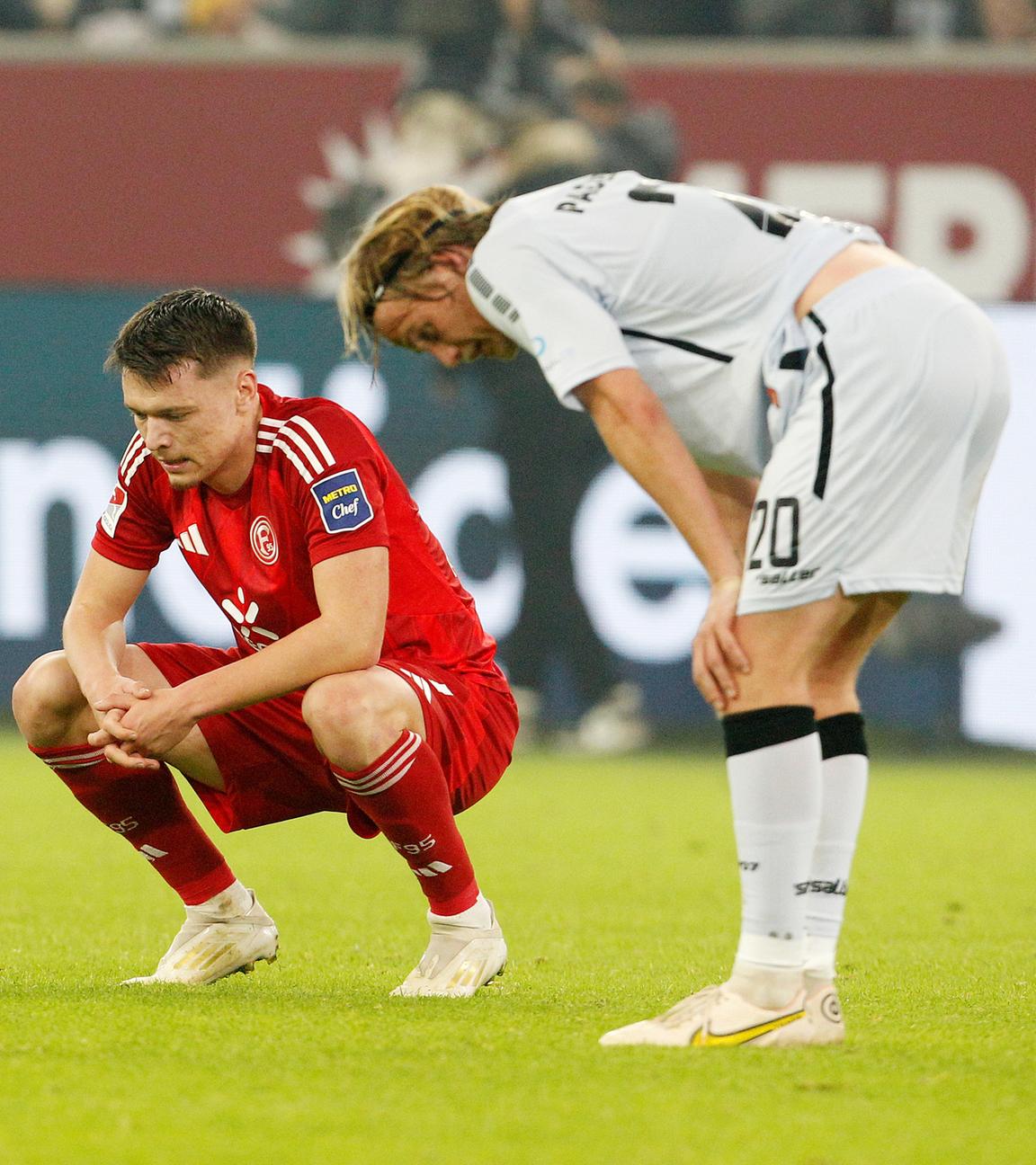 Der Düsseldorfer Dzenan Pejcinovic und der Paderborner Felix Götze stehen erschöpft auf dem Feld nach dem Schlusspfiff.