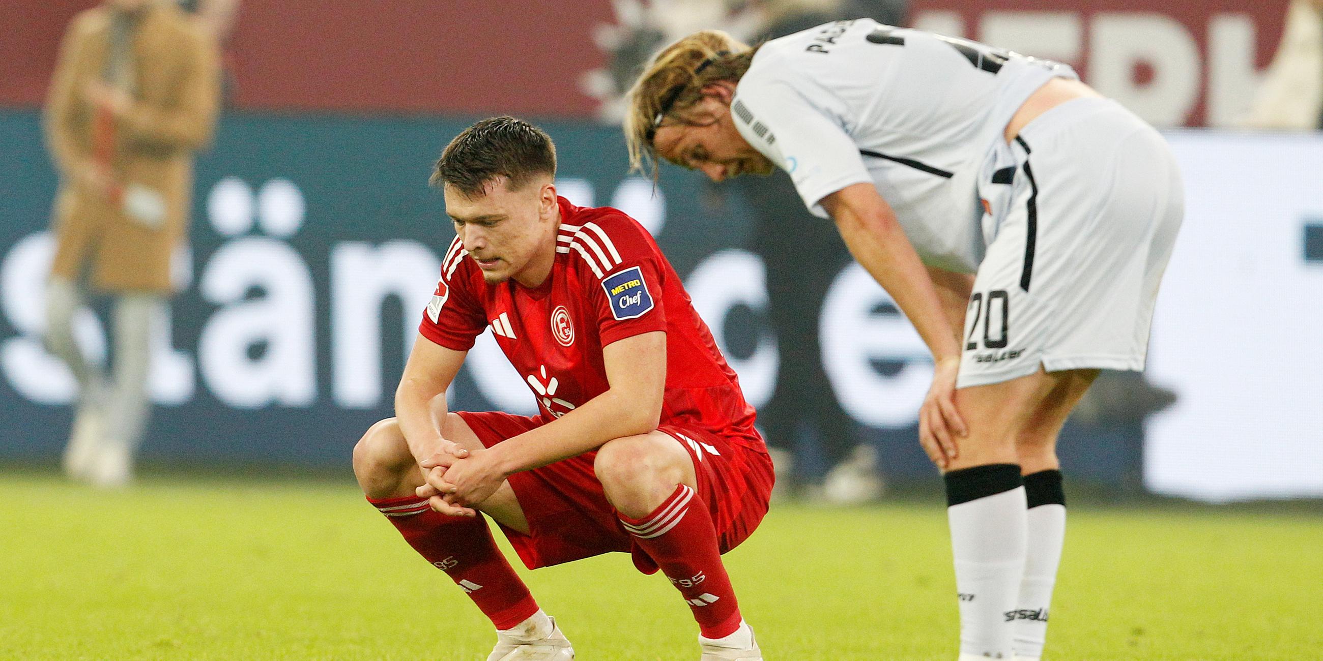 Der Düsseldorfer Dzenan Pejcinovic und der Paderborner Felix Götze stehen erschöpft auf dem Feld nach dem Schlusspfiff.