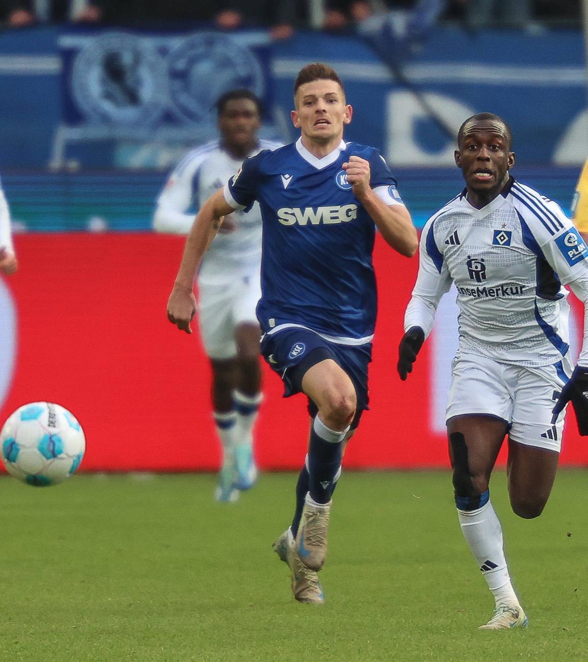 Hamburgs Jean-Luc Dompe und Marvin Wanitzek vom Karlsruher SC kämpfen um den Ball.