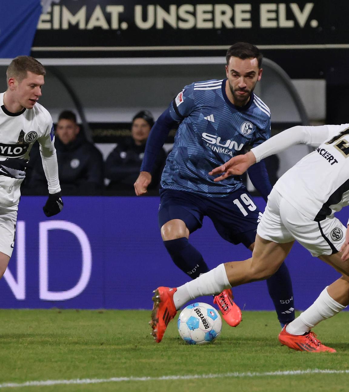 Schalkes Kenan Karamankämpft um den Ball gegen Lukas Pinckert und Elias Baum vom SV Elversberg.