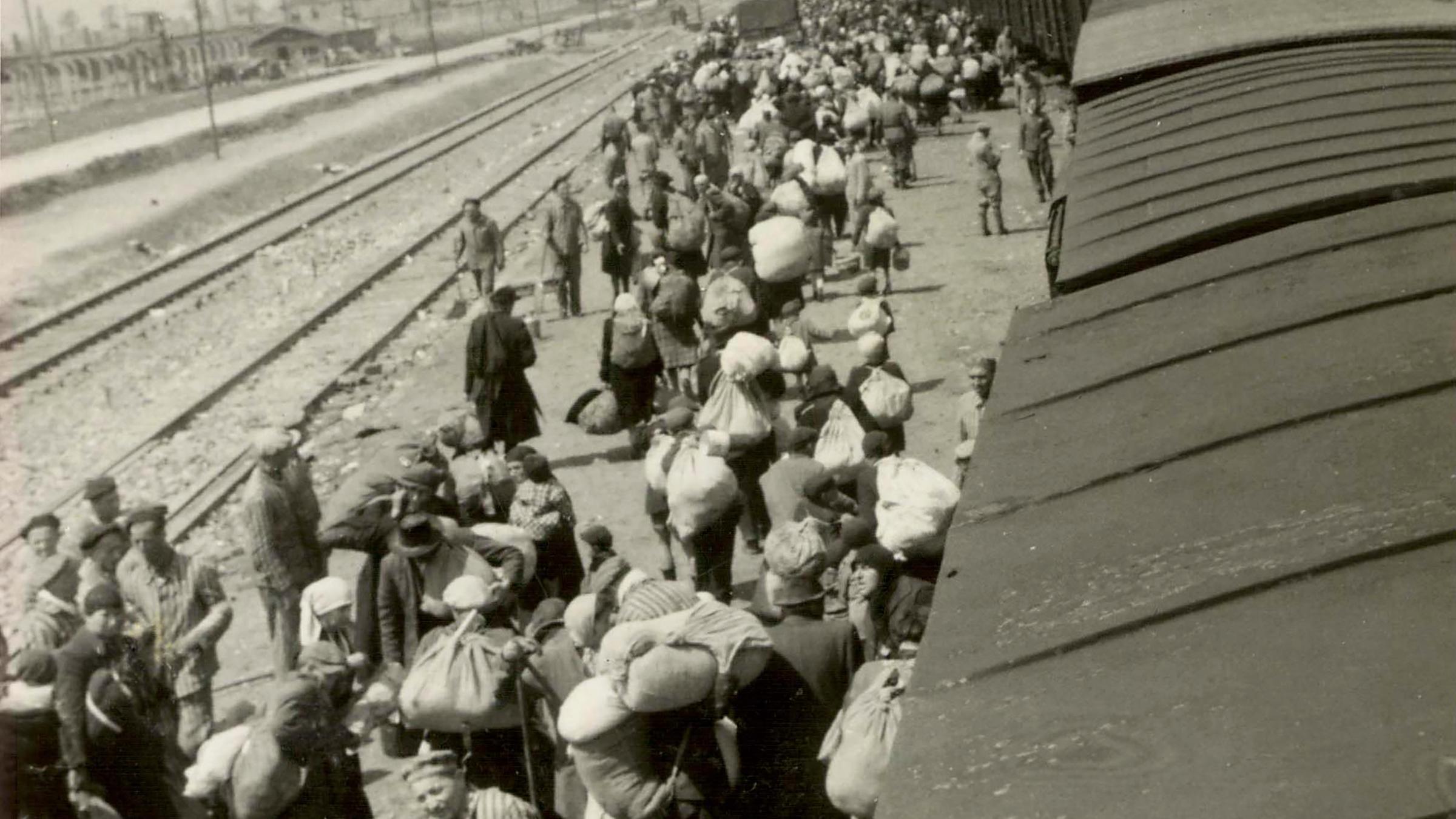 KZ Auschwitz-Birkenau - Die Rampe ist von den Männern in Häftlingskleidung gesäubert und das Gepäck der Opfer ist zur Verwertung wegtransportiert worden.