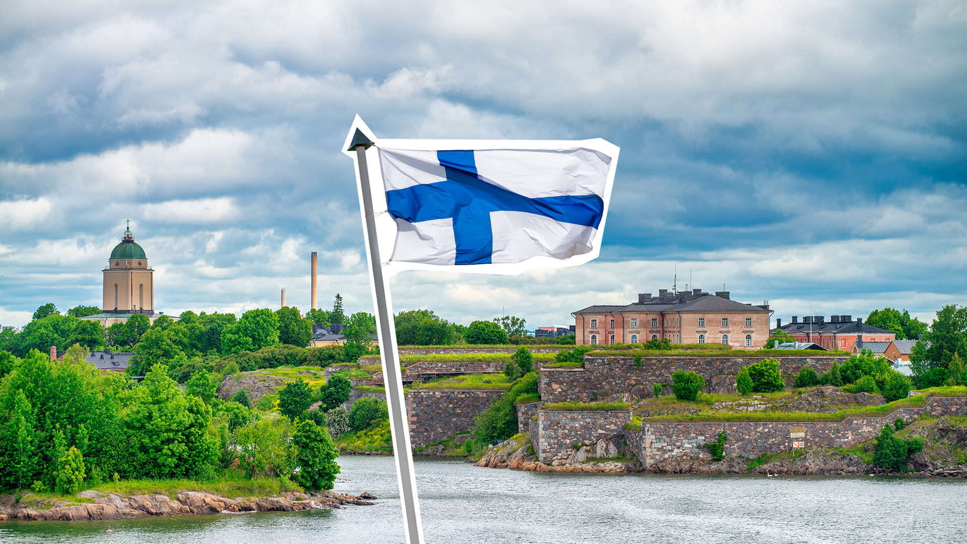 Die Finnische Flagge vor einer Stadtansicht der Hauptstadt Helsinki