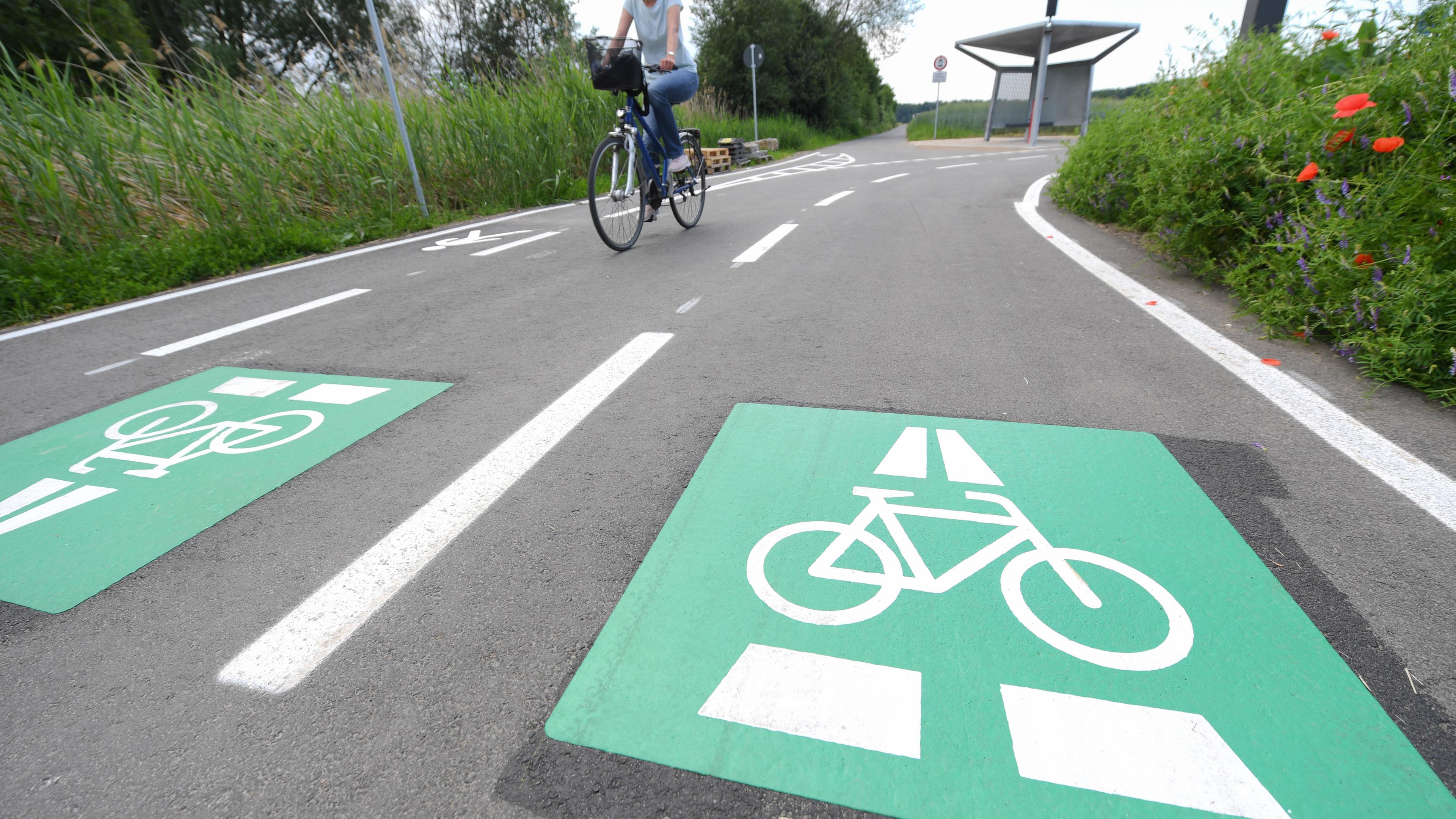 Frau fährt auf Radschnellweg