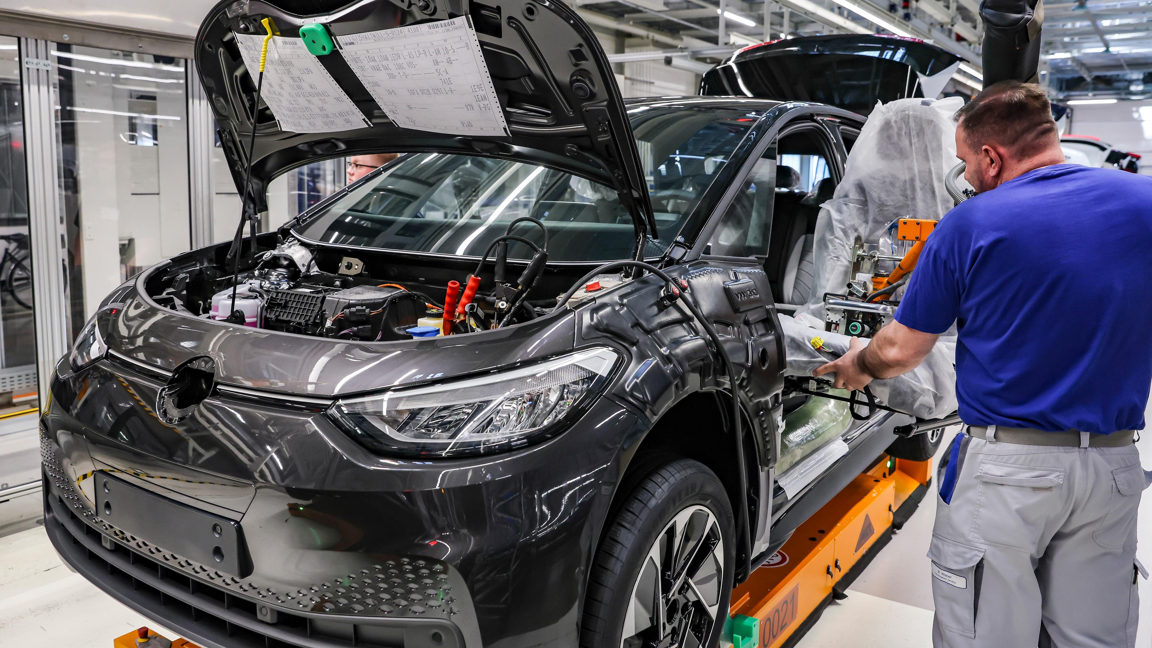 Mitarbeiter montiert Fahrersitz im Werk von Volkswagen in Zwickau