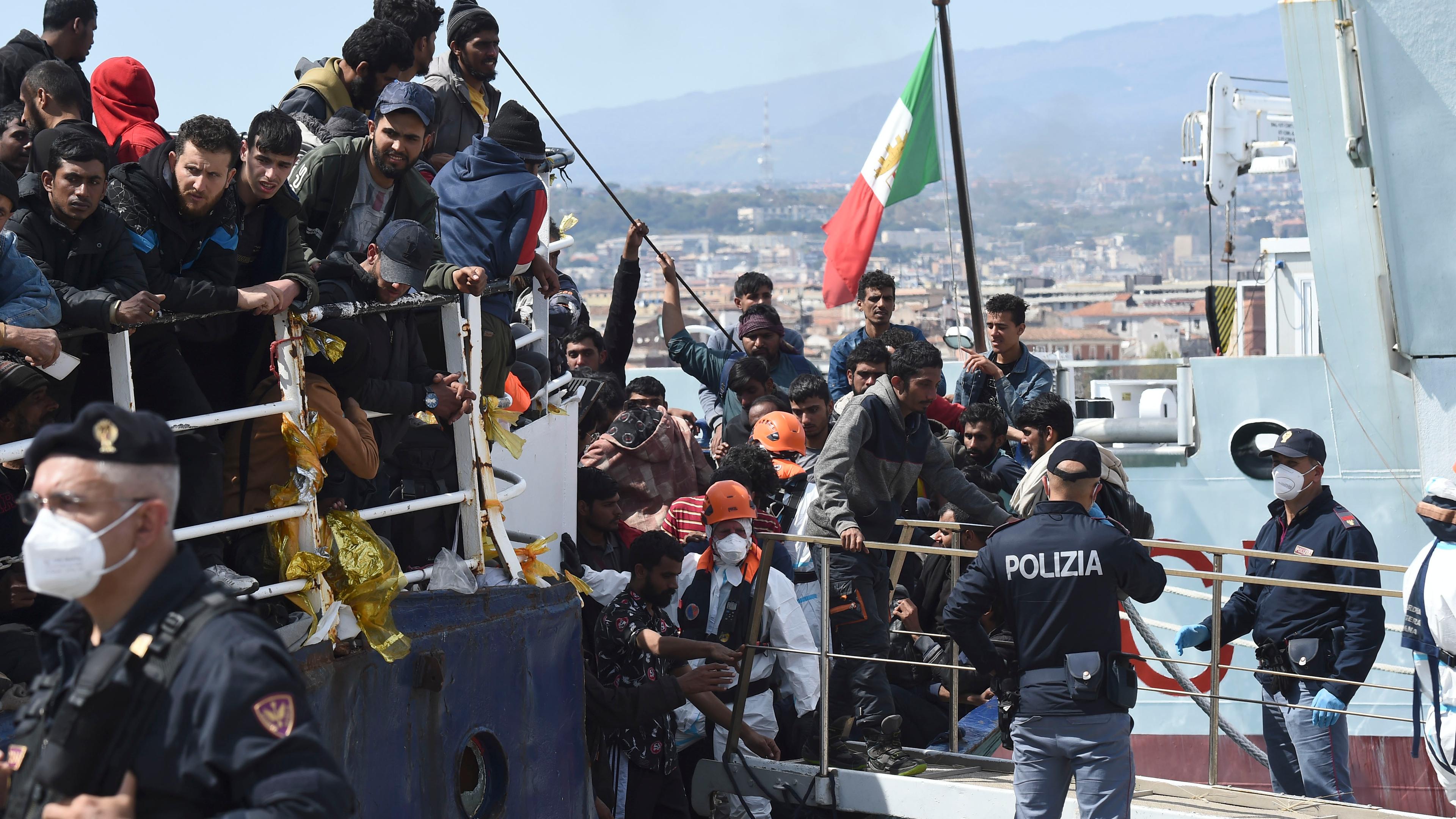 Migranten gehen im sizilianischen Hafen von Catania von Bord eines Schiffes