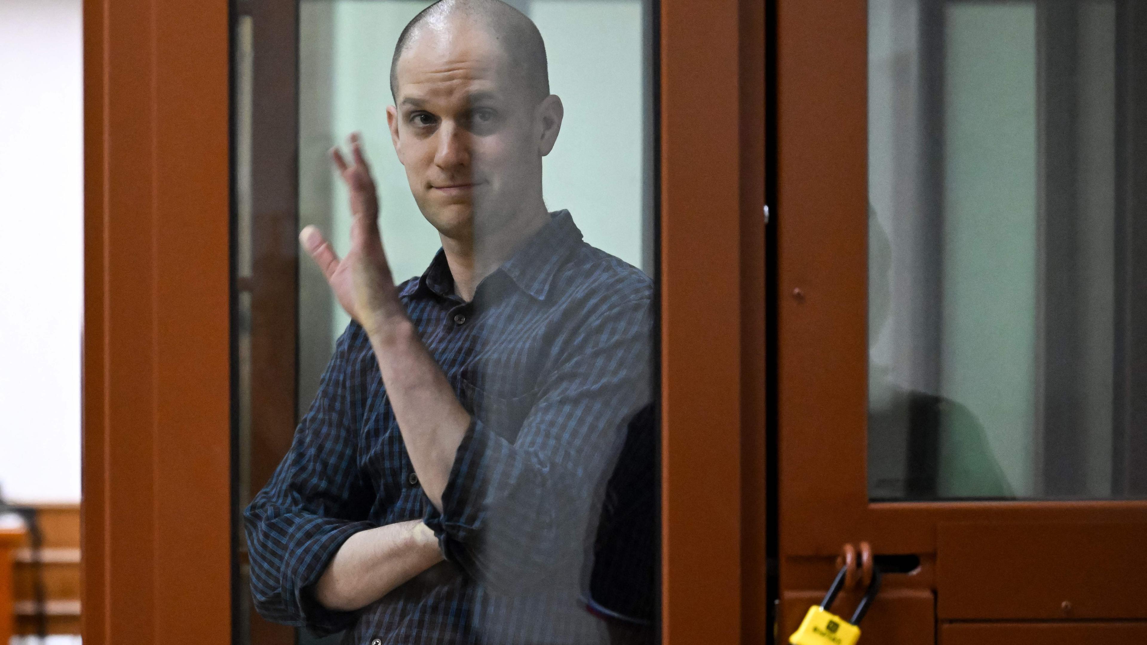 Der wegen Spionage angeklagte US-Journalist Evan Gershkovich gestikuliert vor einer Anhörung im Jekaterinburger Bezirksgericht Swerdlowsk am 26. Juni 2024 in einem gläsernen Angeklagtenkäfig.