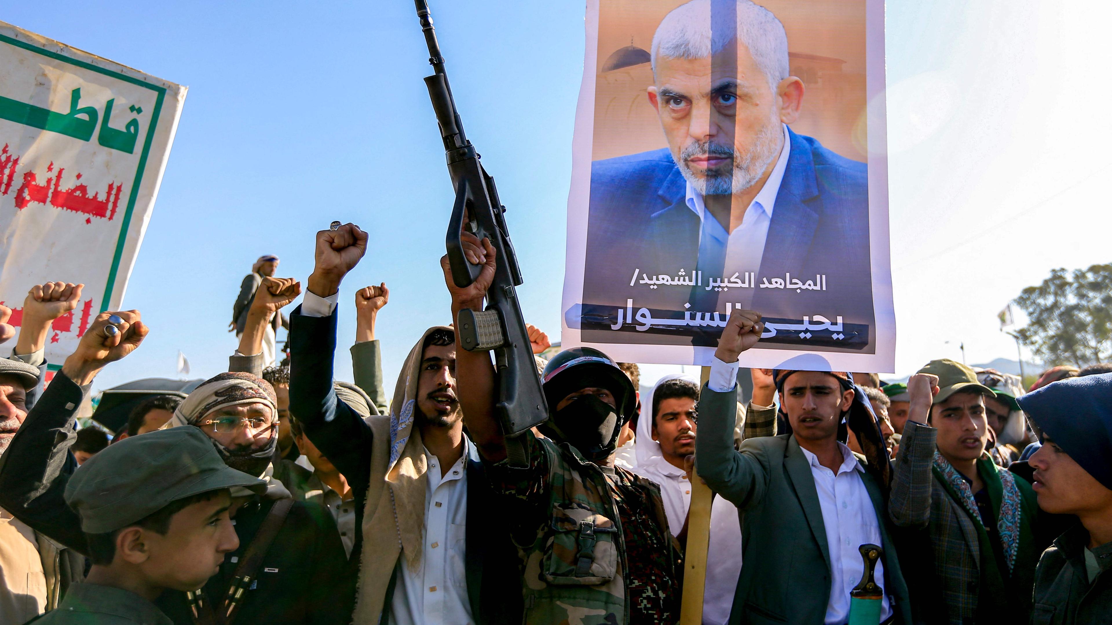 Supporters of Yemen's Huthis chant slogans as they gather with a picture of Hamas' slain leader Yahya Sinwar 