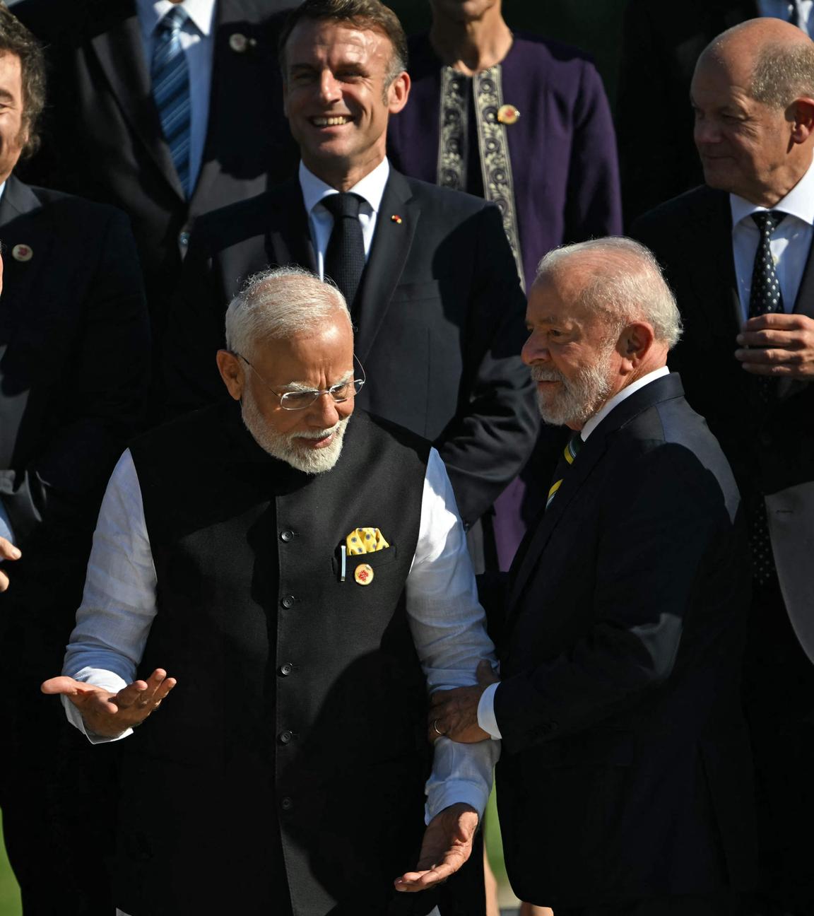 ndia's Prime Minister Narendra Modi (2nd L) speaks with Brazil's President Luiz Inacio Lula da Silva, amid (L to R clockwise) Turkey's President Recep Tayyip Erdogan, Argentina's President Javier Milei, France's President Emmanuel Macron, Germany's Chancellor Olaf Scholz and South Africa_s President Cyril Ramaphosa during a group photo at the end of the first session of the G20 Leaders' Meeting in Rio de Janeiro, Brazil