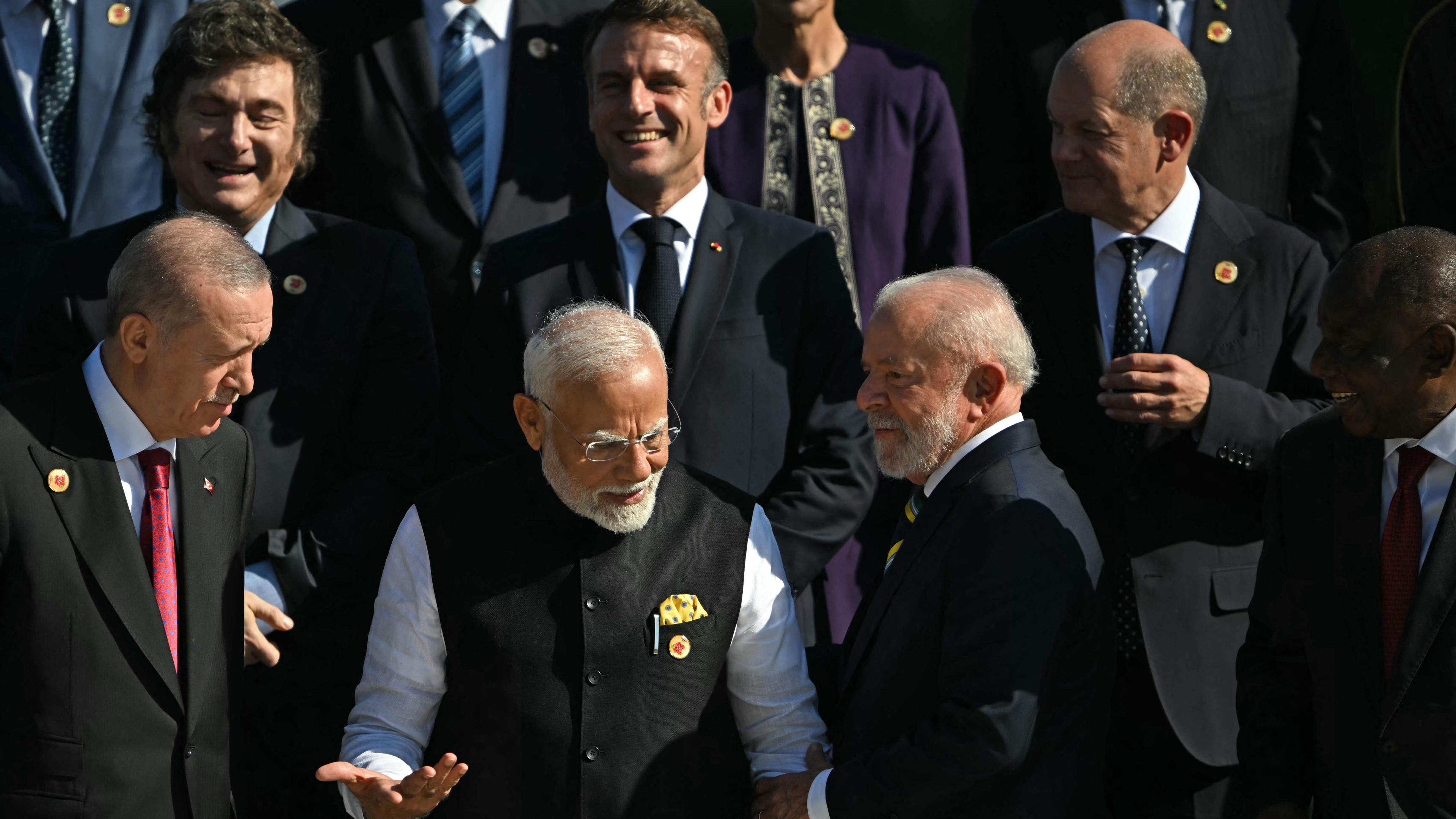 ndia's Prime Minister Narendra Modi (2nd L) speaks with Brazil's President Luiz Inacio Lula da Silva, amid (L to R clockwise) Turkey's President Recep Tayyip Erdogan, Argentina's President Javier Milei, France's President Emmanuel Macron, Germany's Chancellor Olaf Scholz and South Africa_s President Cyril Ramaphosa during a group photo at the end of the first session of the G20 Leaders' Meeting in Rio de Janeiro, Brazil