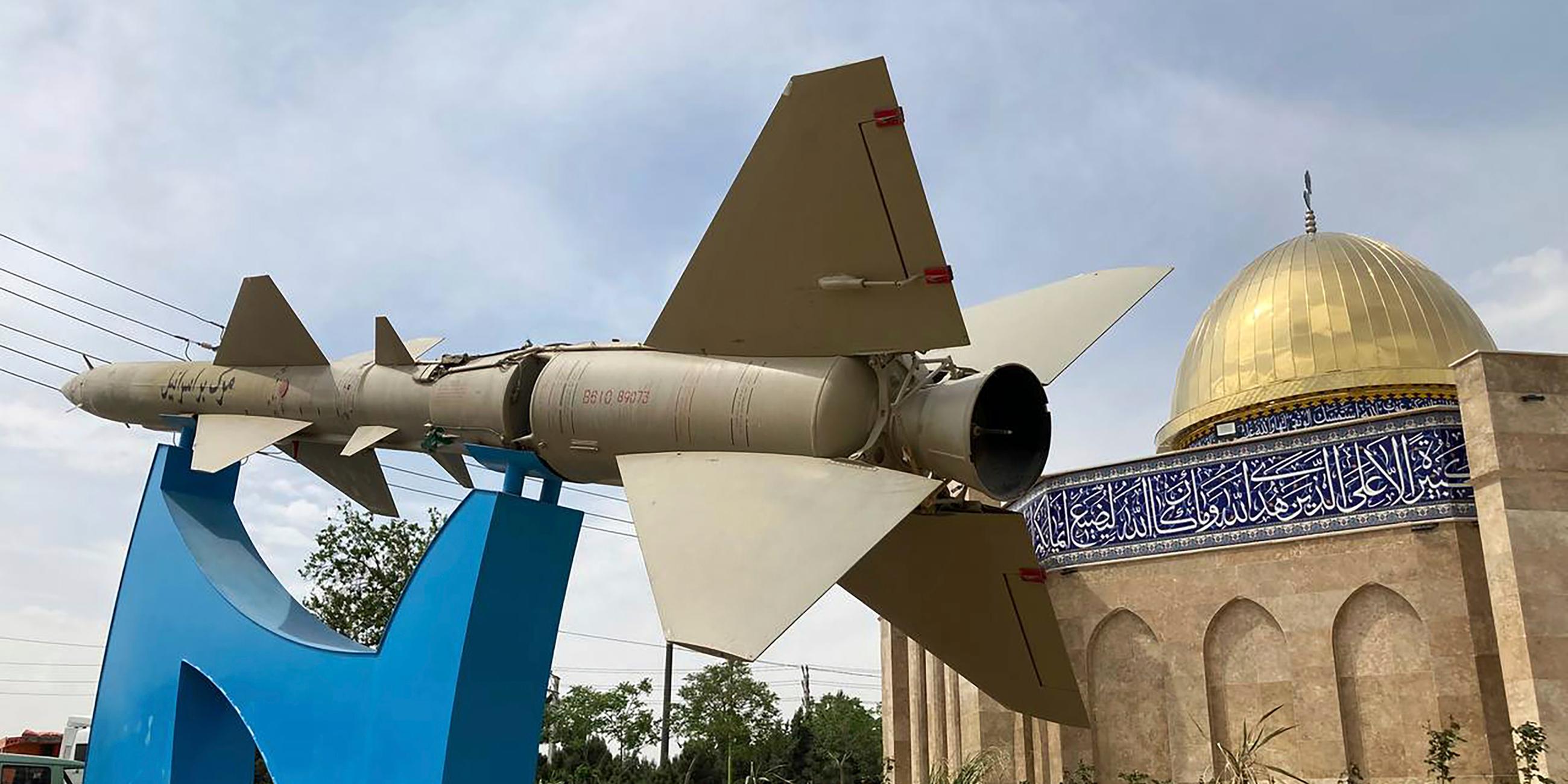 Eine Rakete steht mit einem Schild in Farsi: "Tod für Israel" vor einer Moschee in Form des Felsendoms von Jerusalem am Eingang der Quds-Stadt westlich der Hauptstadt Teheran, Iran, Sonntag, 21. April 2024.