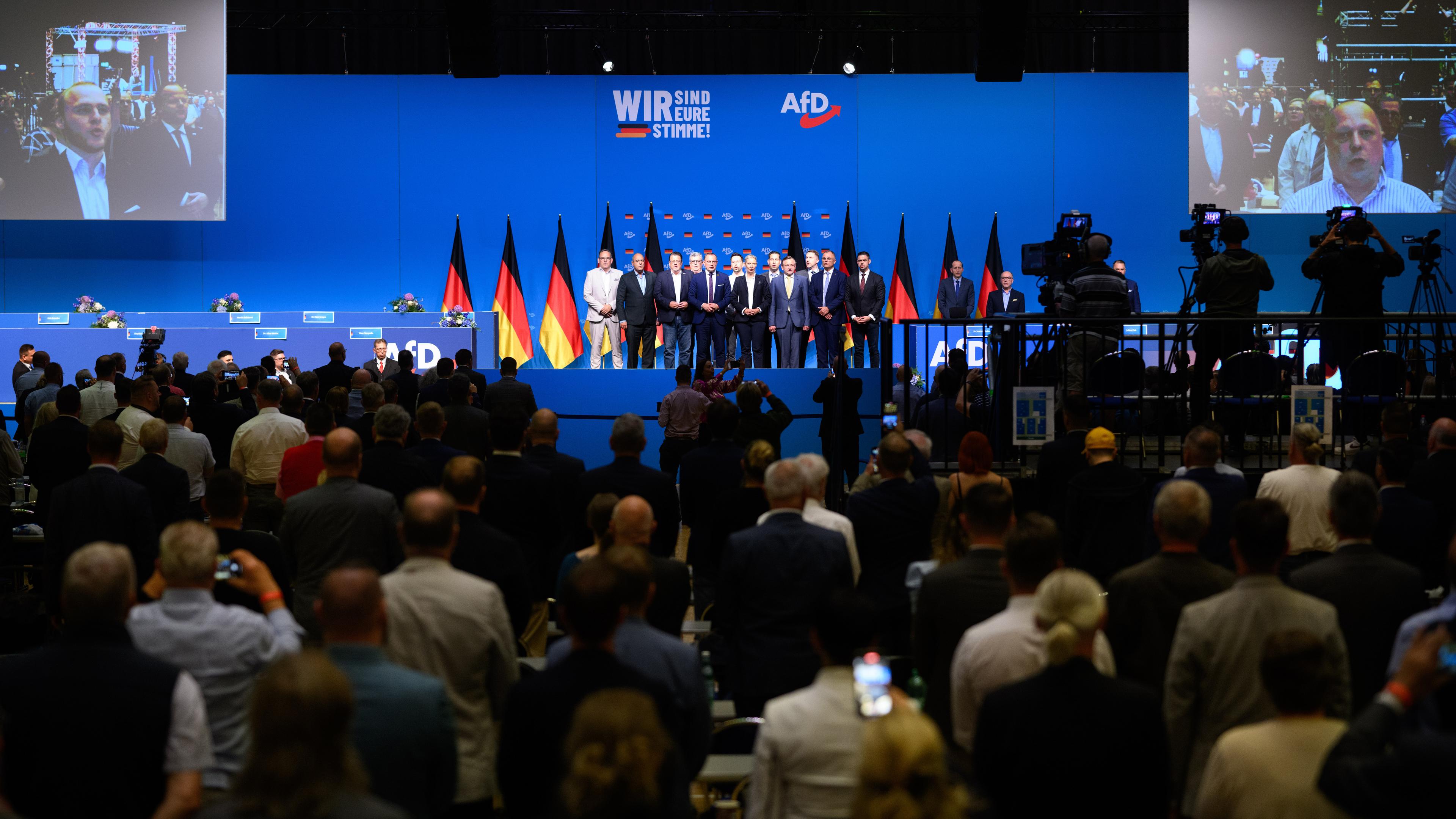 Tino Chrupalla (5.v.l.), Bundesvorsitzender der AfD, und Alice Weidel 6.v.r.), Bundesvorsitzende der AfD, stehen zum Abschluss beim Bundesparteitag der AfD in der Grugahalle in Essen mit dem neugewählten Bundesvorstand auf der Bühne und singen die Nationalhymne.