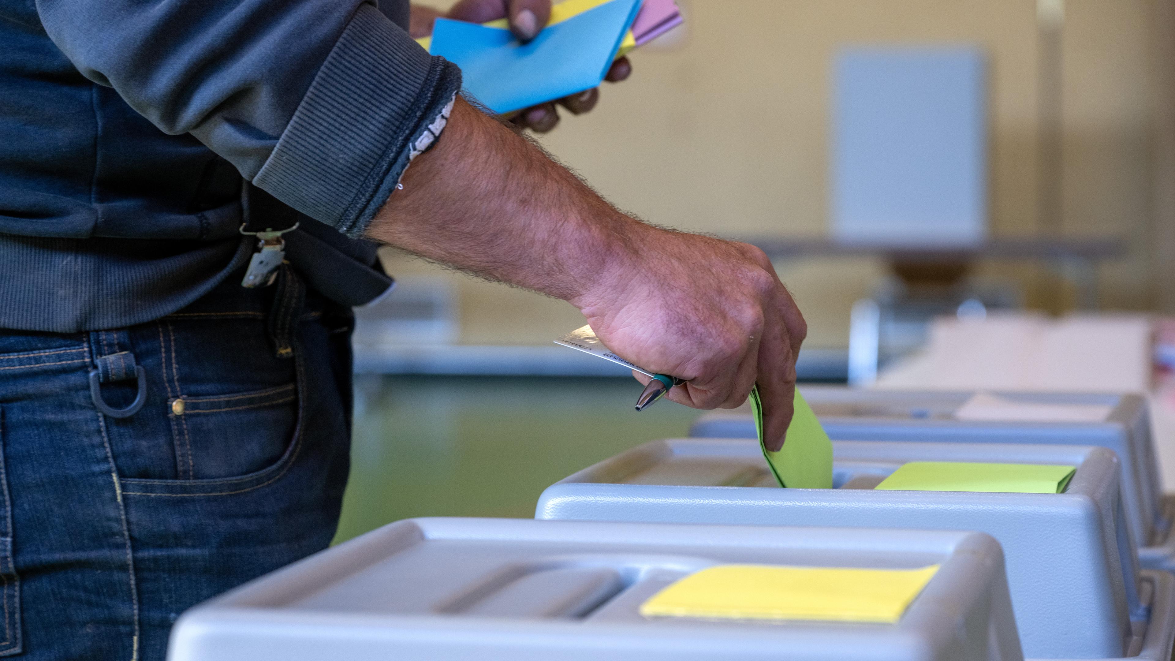 09.06.2024, Rheinland-Pfalz, Schweich: Ein Mann wirft seine Stimzettel in die Wahlurne, um seine Stimmen abzugeben.