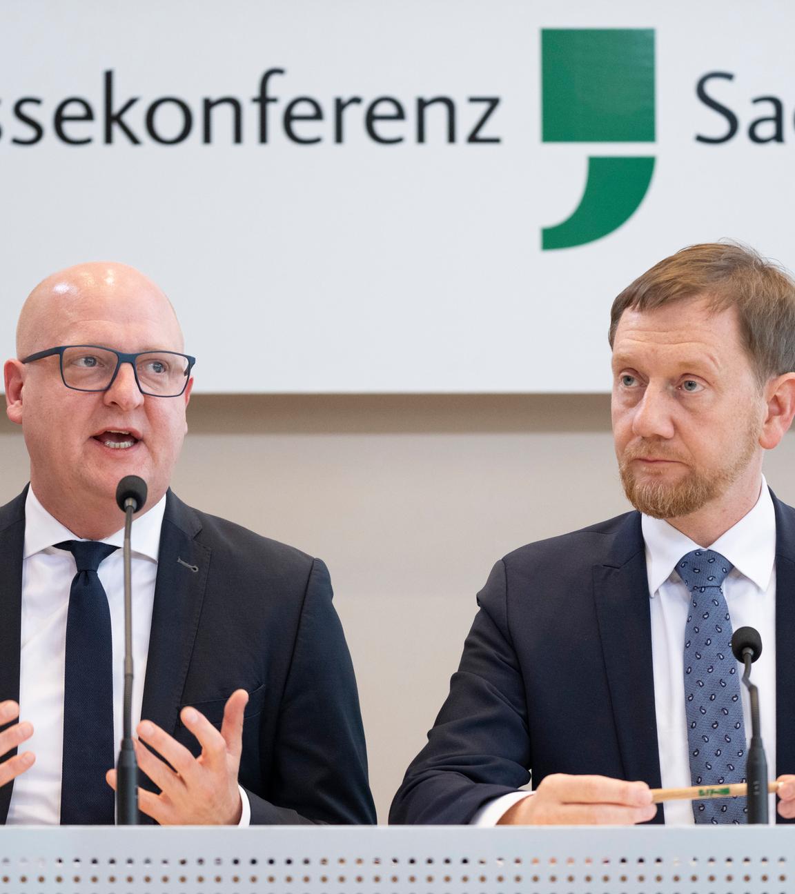 Henning Homann (l), Co-Vorsitzender der SPD in Sachsen, und Michael Kretschmer (CDU), Ministerpräsident von Sachsen, nehmen an einer Pressekonferenz im Landtag teil. CDU und SPD in Sachsen wollen in einer gemeinsamen Minderheitsregierung anderen Parteien die Hand reichen.