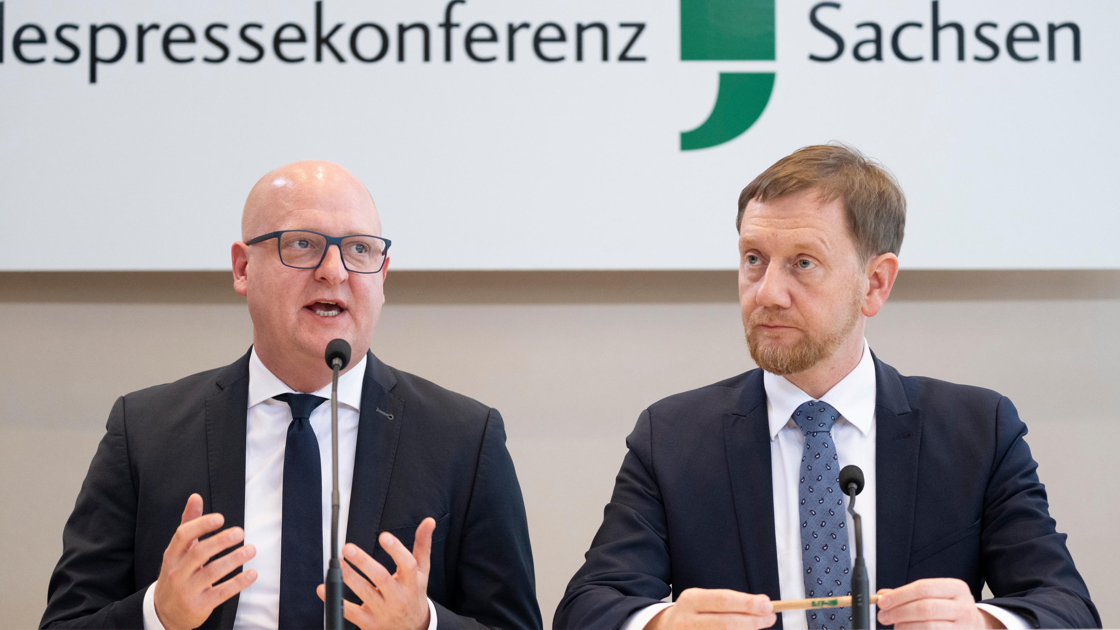 Henning Homann (l), Co-Vorsitzender der SPD in Sachsen, und Michael Kretschmer (CDU), Ministerpräsident von Sachsen, nehmen an einer Pressekonferenz im Landtag teil. CDU und SPD in Sachsen wollen in einer gemeinsamen Minderheitsregierung anderen Parteien die Hand reichen.