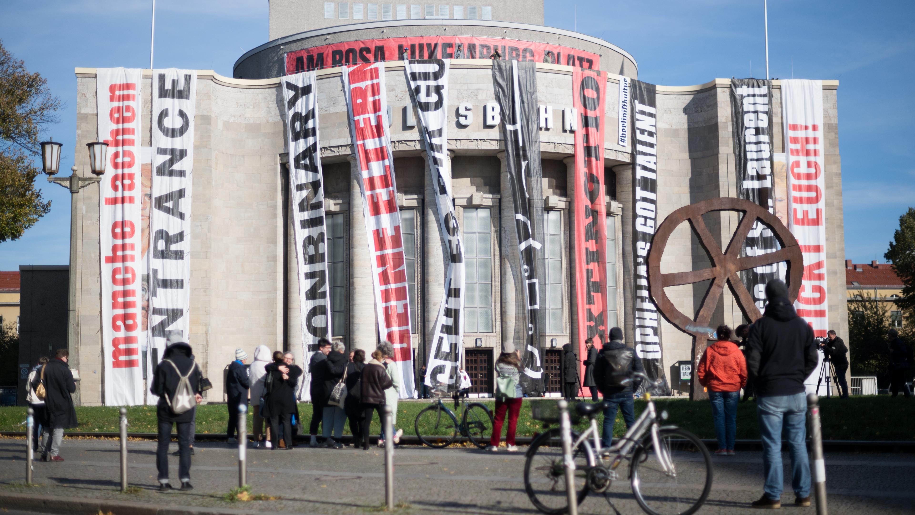 16.10.2024, Berlin: Die Fassade der Volksbühne wird im Rahmen des Aktionstag #BerlinistKultur gegen drohende Kürzungen im Berliner Kulturbereich mit Bannern von Aufführungen verhüllt.