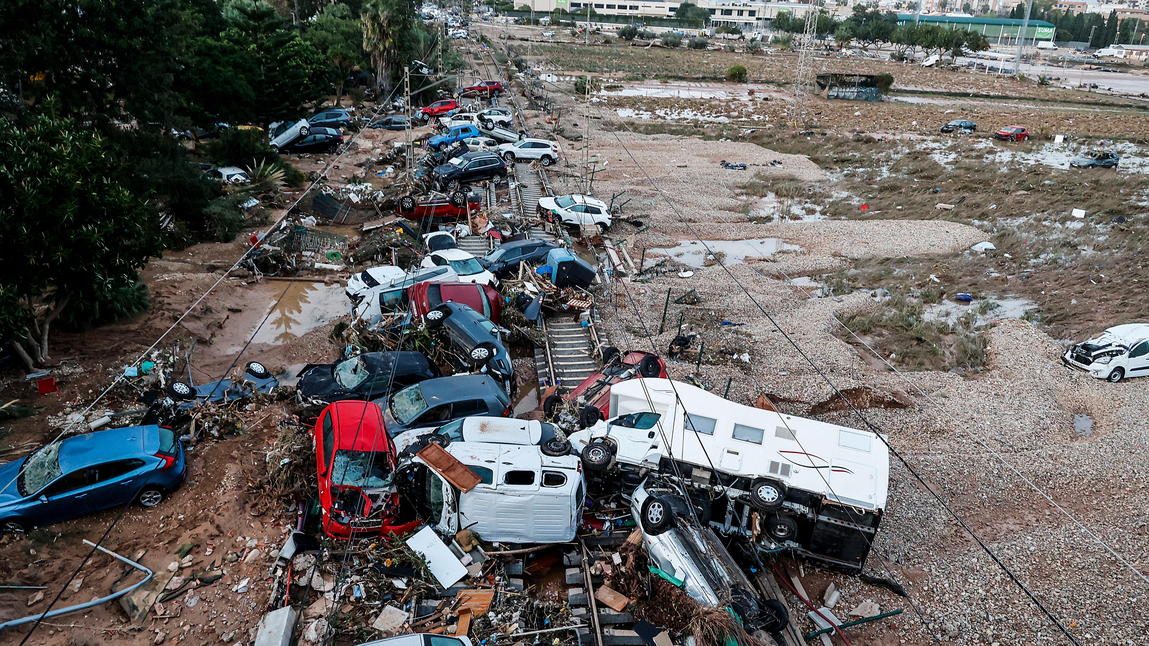 30.10.2024, Spanien, Valencia (valencianische Gemeinschaft): Autos, die durch das heftige Unwetter weggeschwemmt wurden, stehen auf den Gleisen. 