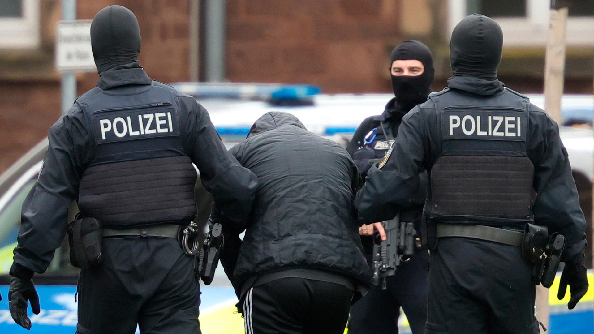 Federal Police officers lead the arrested Libyan suspect Omar A. (C) from a helicopter for his arraignment at the Federal Supreme Court (BGH) in Karlsruhe, Germany, 20 October 2024.