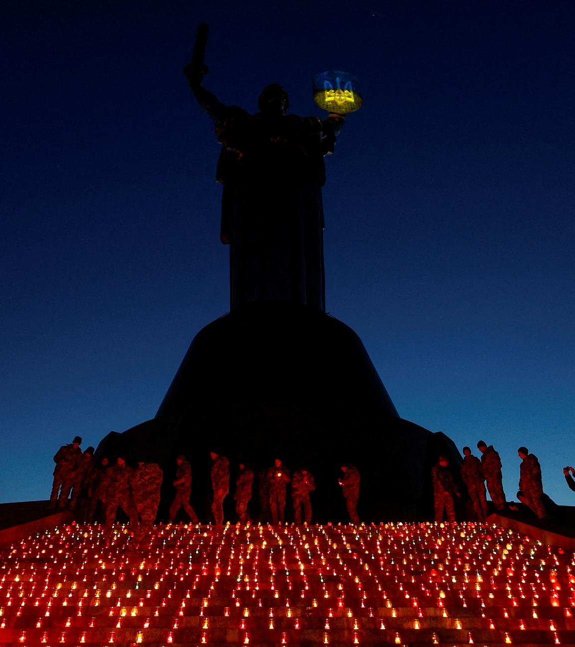 Military cadets light candles during a commemorative ceremony on the 1000th day of Russia's full scale attack on Ukraine, in front of the 'Motherland' monument in Kyiv, Ukraine