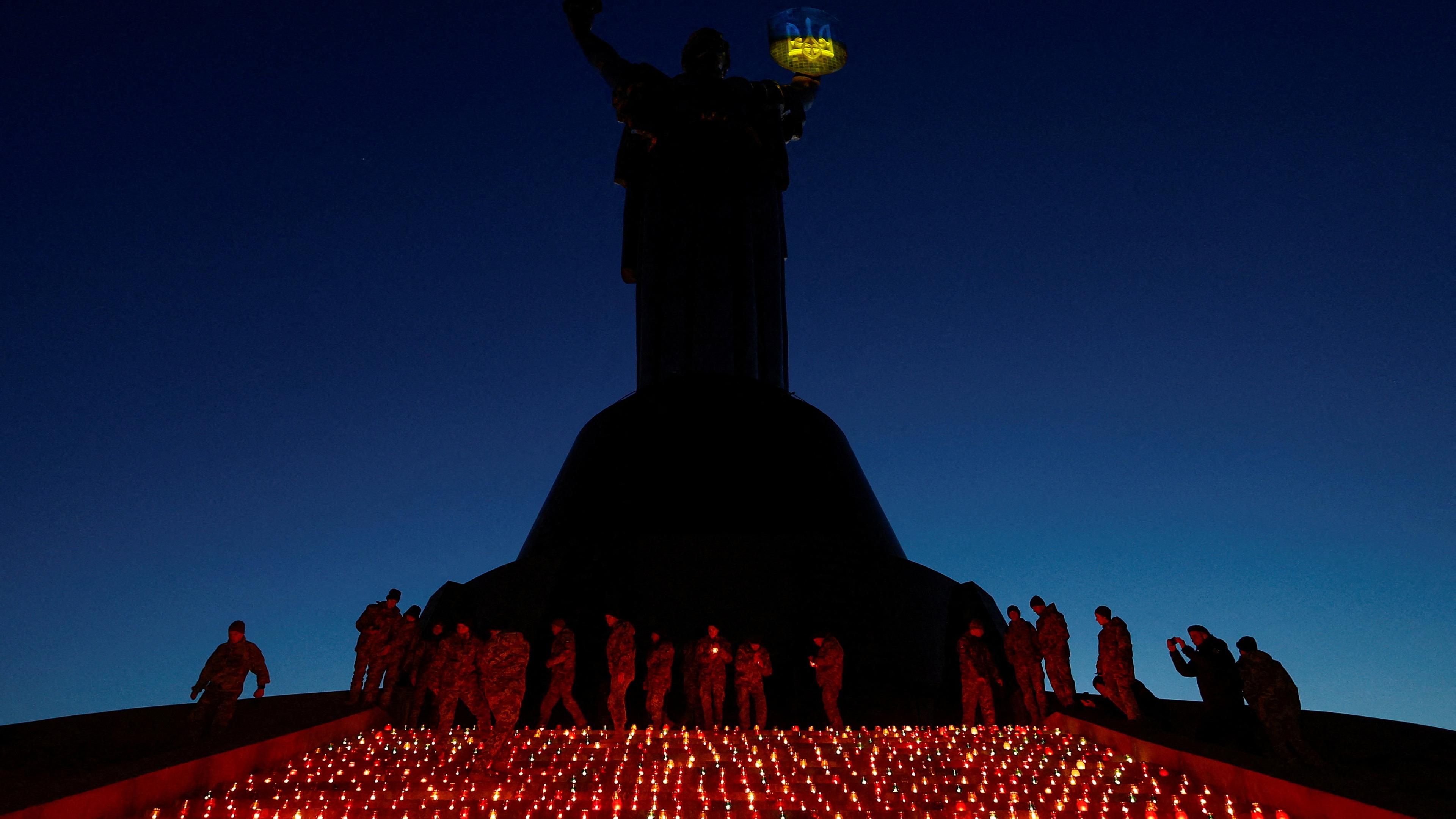 Military cadets light candles during a commemorative ceremony on the 1000th day of Russia's full scale attack on Ukraine, in front of the 'Motherland' monument in Kyiv, Ukraine