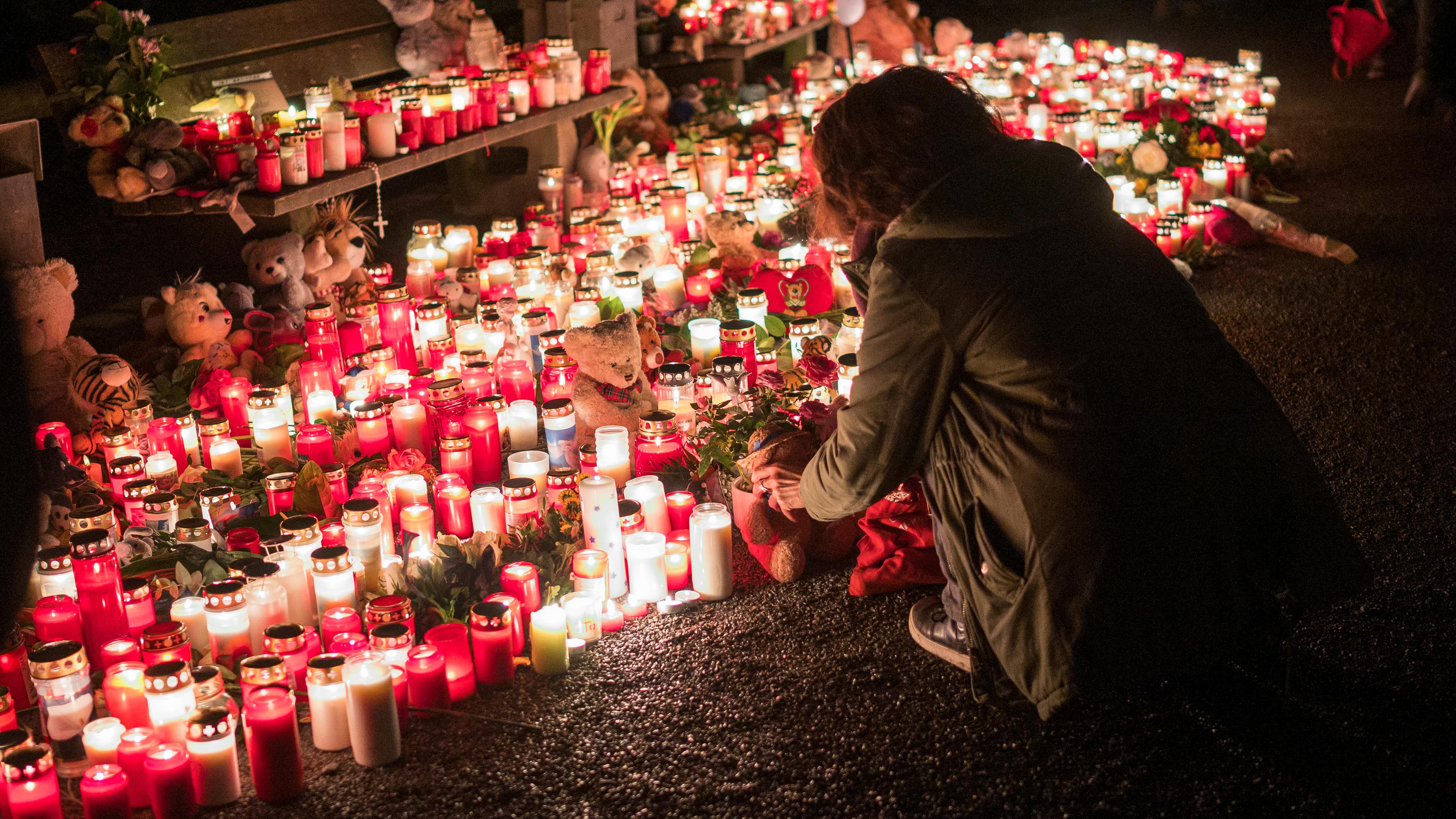 23.01.2025, Bayern, Aschaffenburg: Eine Person legt nach der tödlichen Messerattacke im Park Schöntal einen Teddybären bei einer Gedenkstätte nieder. 