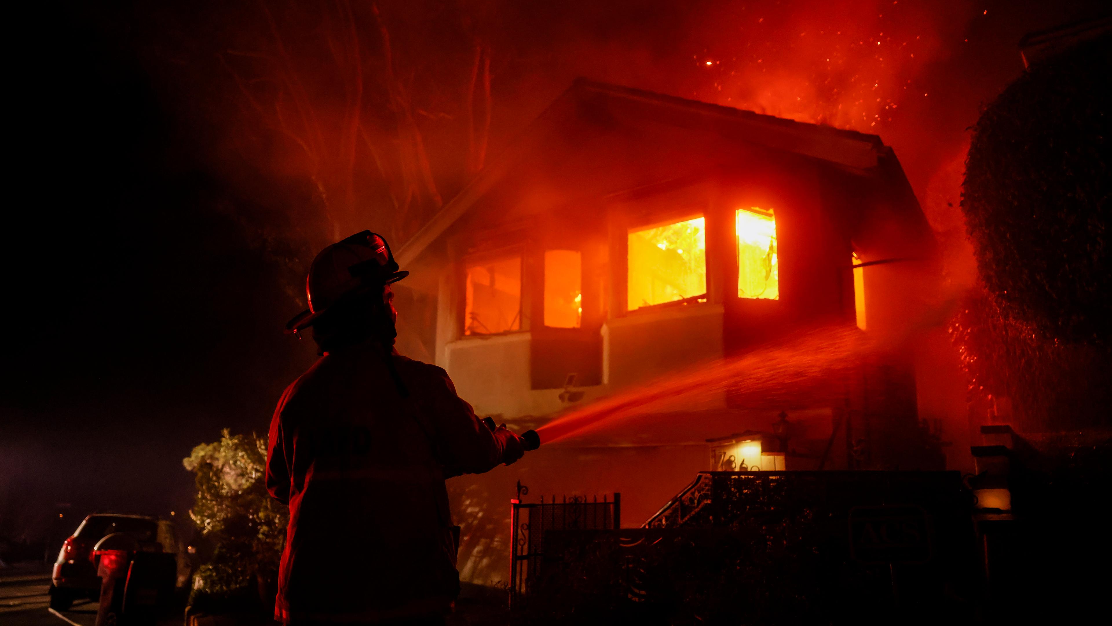 Ein Feuerwehrmann arbeitet, während das Palisades-Feuer in Pacific Palisades, Kalifornien, ein Haus auf dem Hügel nahe der Getty-Villa niederbrennt. 