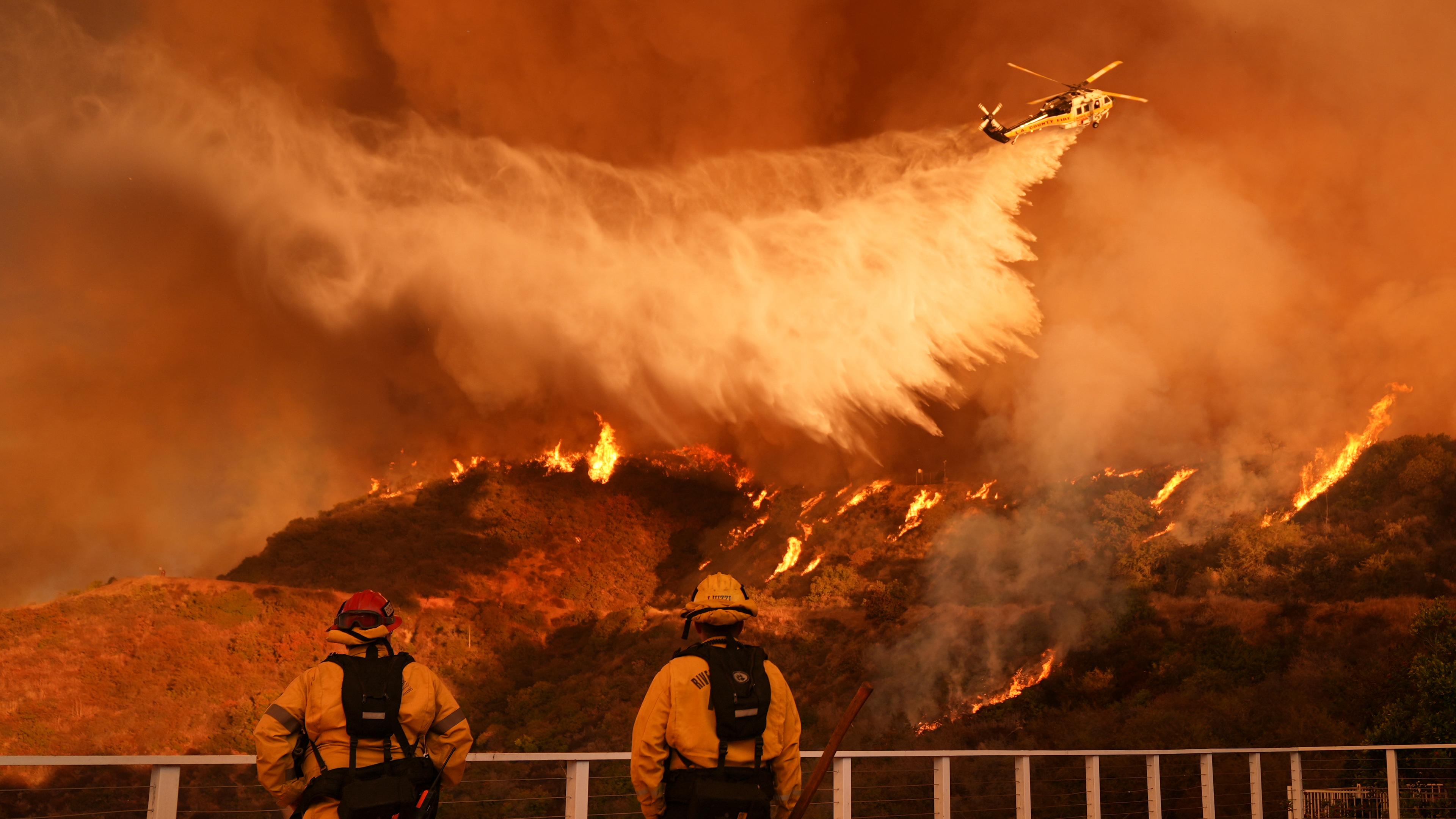 Los Angeles: Feuerwehrleute beobachten, wie Löschwasser auf das Palisades-Feuer im Mandeville Canyon Angeles geworfen wird