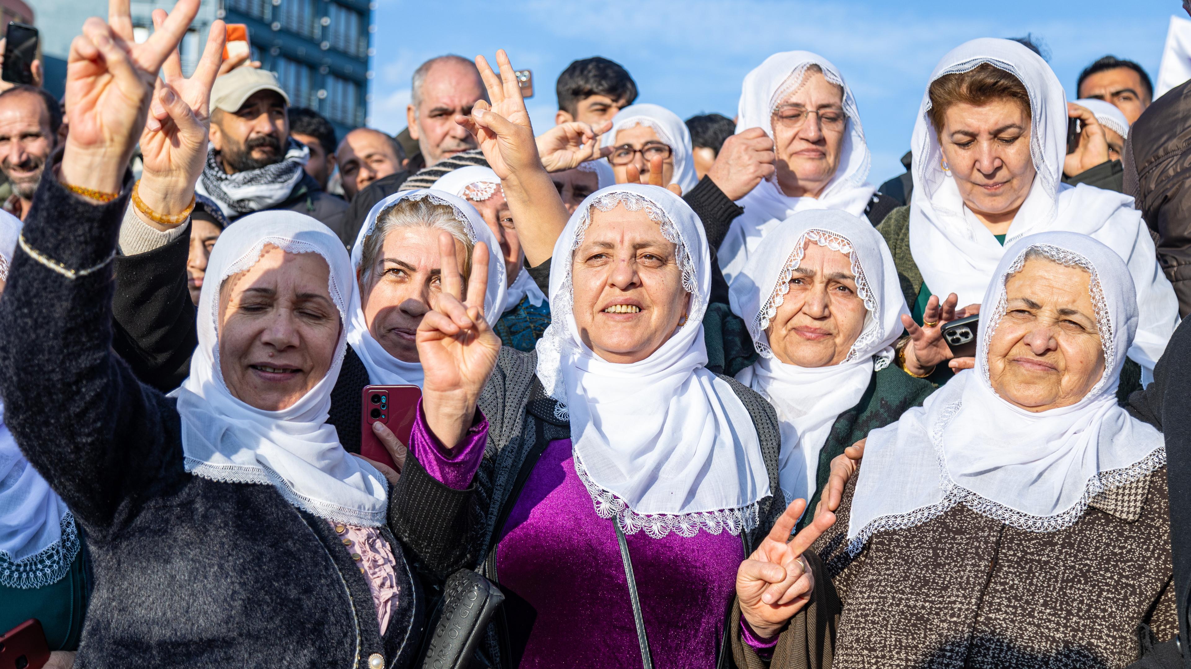 Anhänger der türkischen pro-kurdischen Partei für Gleichheit und Demokratie (DEM) feiern, während sie auf einem Bildschirm eine Pressekonferenz einer DEM-Delegation nach ihrem Besuch beim inhaftierten Führer der Arbeiterpartei Kurdistans (PKK), Abdullah Öcalan, in Diyarbakir, Türkei, am 27. Februar 2025 verfolgen. Auf der Pressekonferenz der DEM am 27. Februar wurde ein Brief des inhaftierten militanten PKK-Führers verlesen, in dem Abdullah Öcalan die kurdische Gruppe auffordert, ihre Waffen niederzulegen