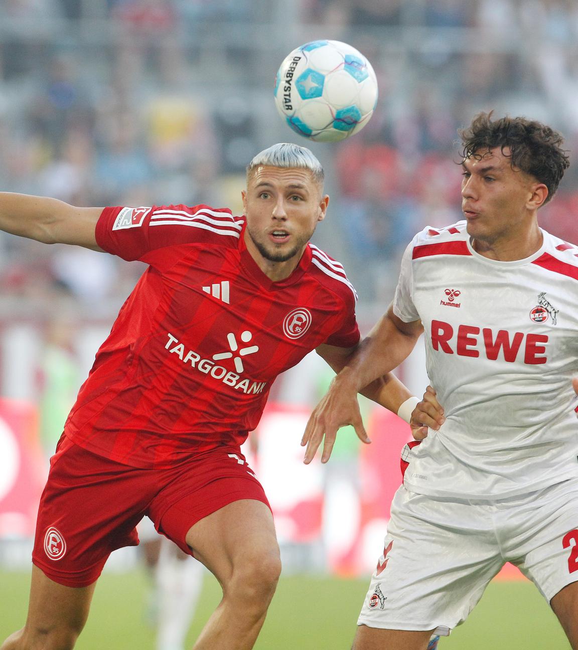 Fortuna Düsseldorf Jona Niemiec  und Kölns Julian Pauli kämpfen um den Ball.