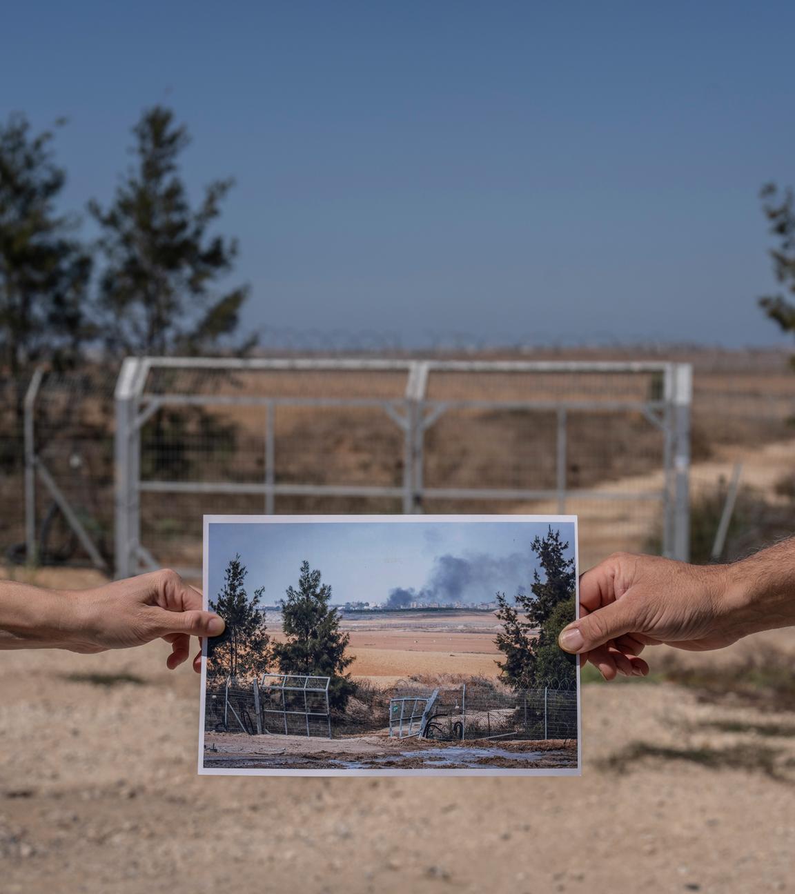 Zwei Menschen halten ein Foto, das die zerstörte Barriere zum Gazastreifen inmitten der Kämpfe zwischen Israel und der Hamas am 10. Oktober 2023 zeigt, aufgenommen an der gleichen Stelle am 26. September 2024.