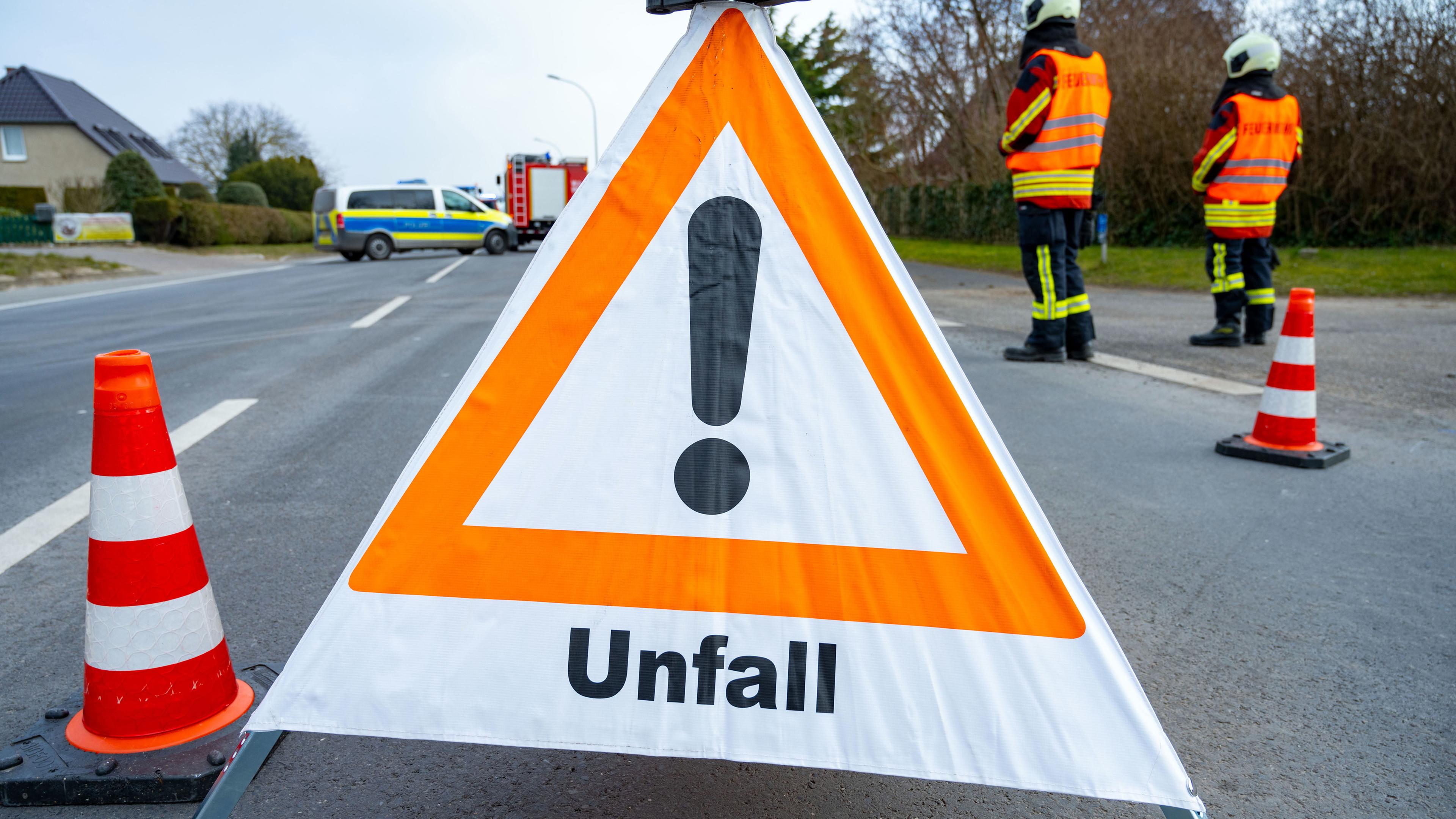 Symbolbild: Ein Warndreieck steht vor einer Unfallstelle auf der Straße