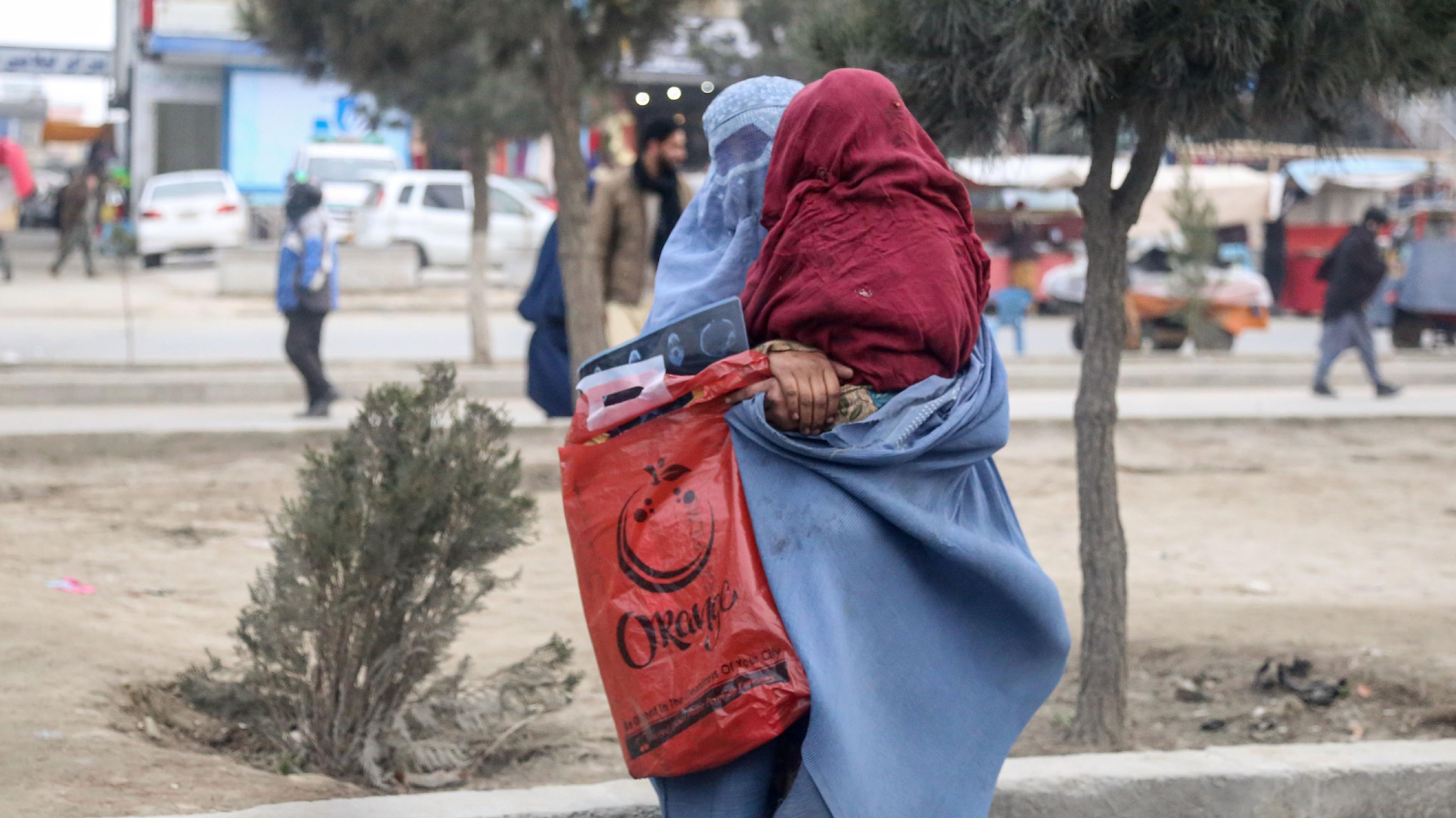 Afghanistan: Eine Frau mit Burka mit Kind auf dem Arm in Kabul, Afghanistan. 