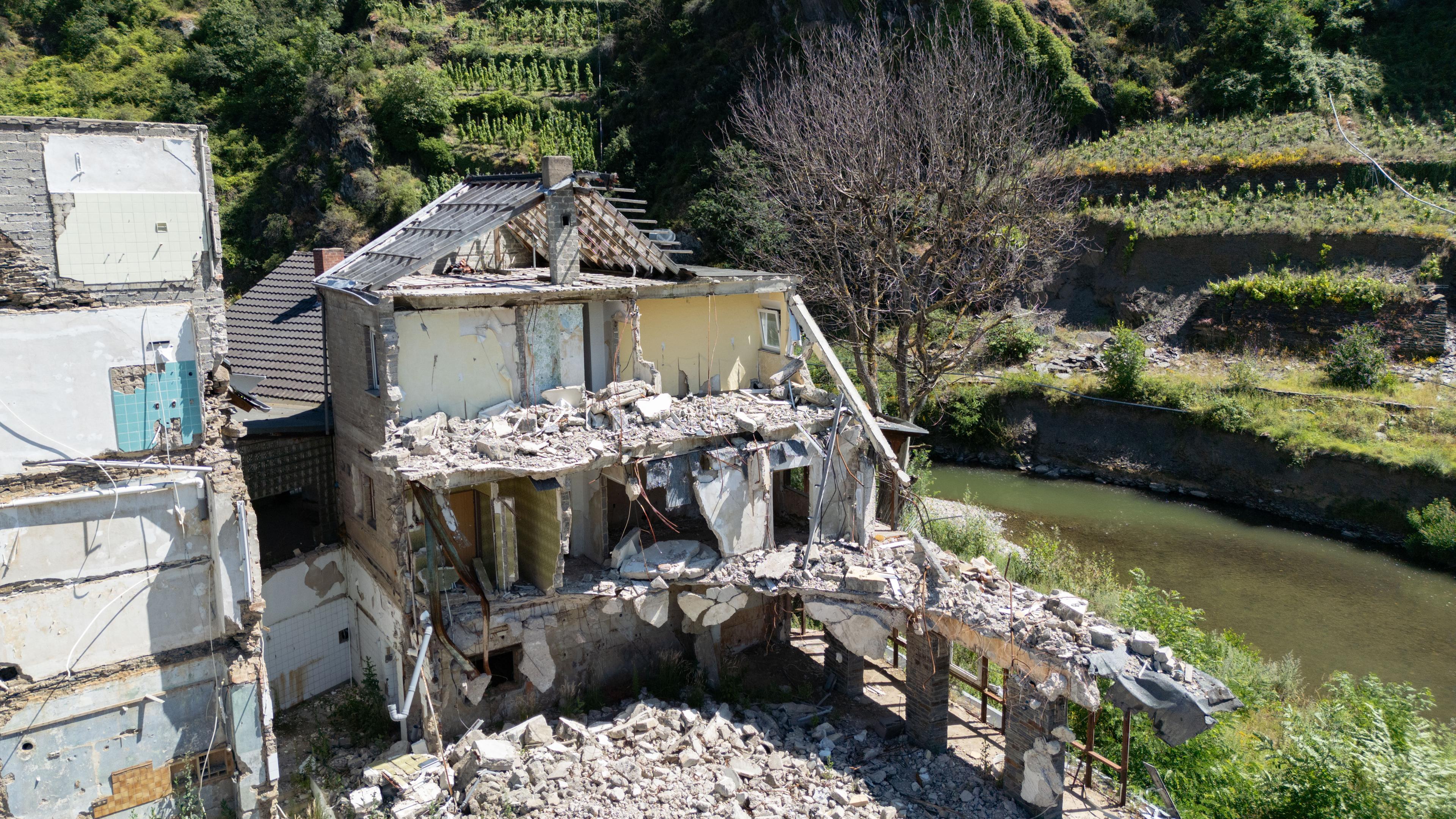 Die Ruinen von zwei bei der Flut im Sommer 2021 zerstörten Wohnhäusern stehen am Ufer der Ahr.
