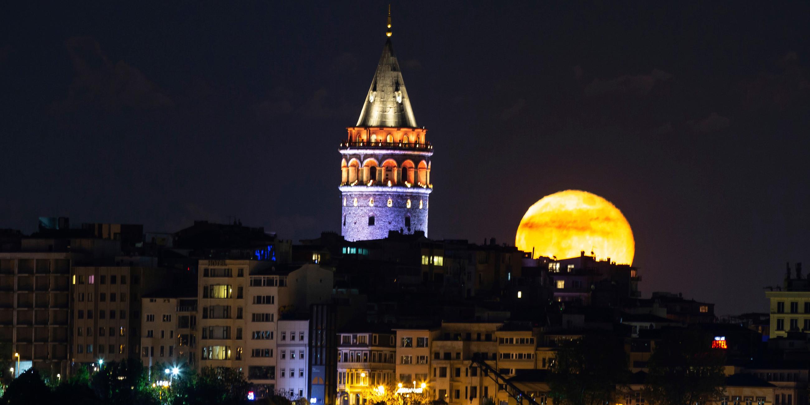 der mond steht hinter der skyline von istanbul