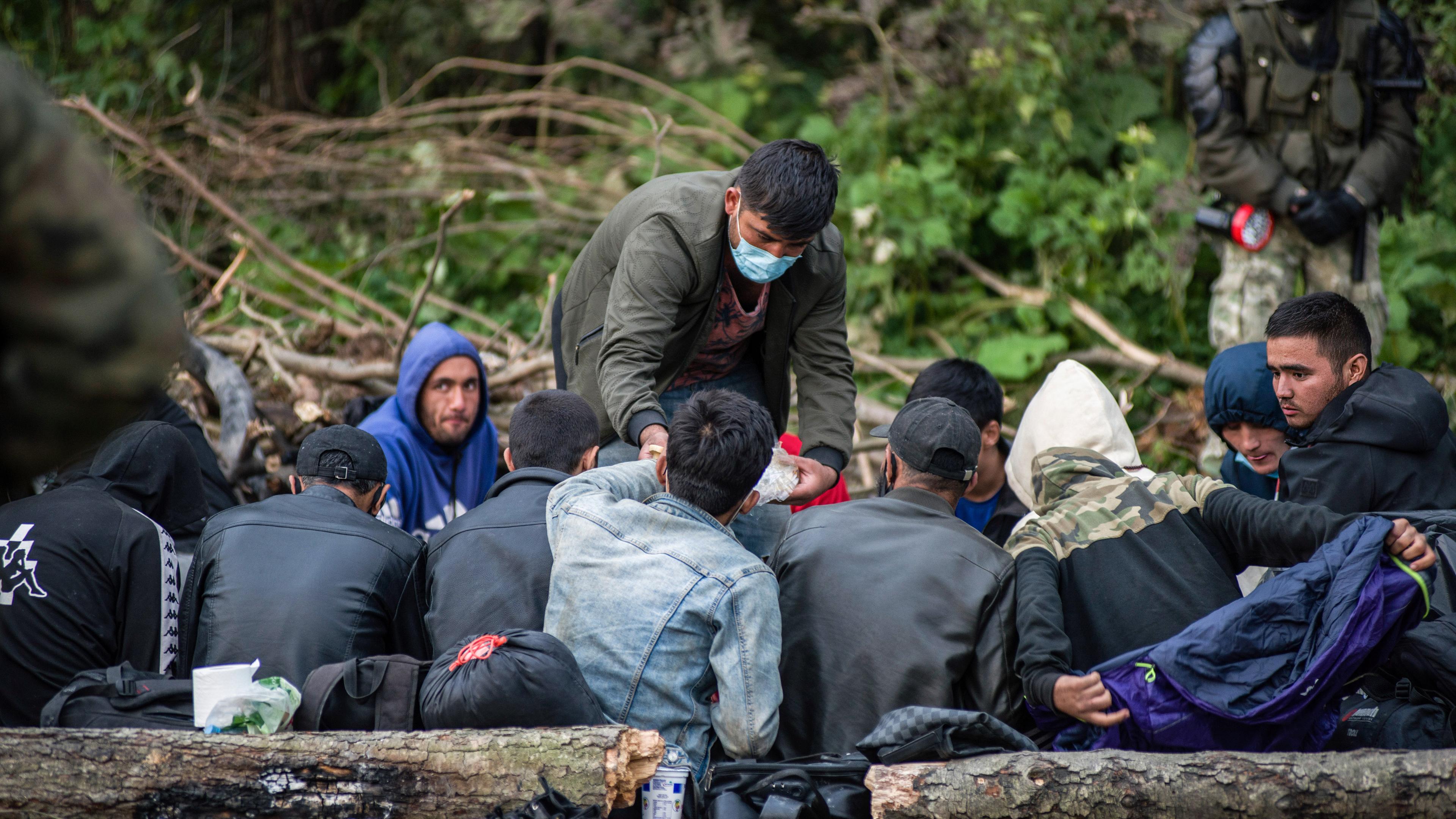ARCHIV - 19.08.2021, Polen, Usnarz Gorny: Afghanische Flüchtlinge, die an der polnisch-belarussischen Grenze festsitzen, warten in einem behelfsmäßigen Lager. 