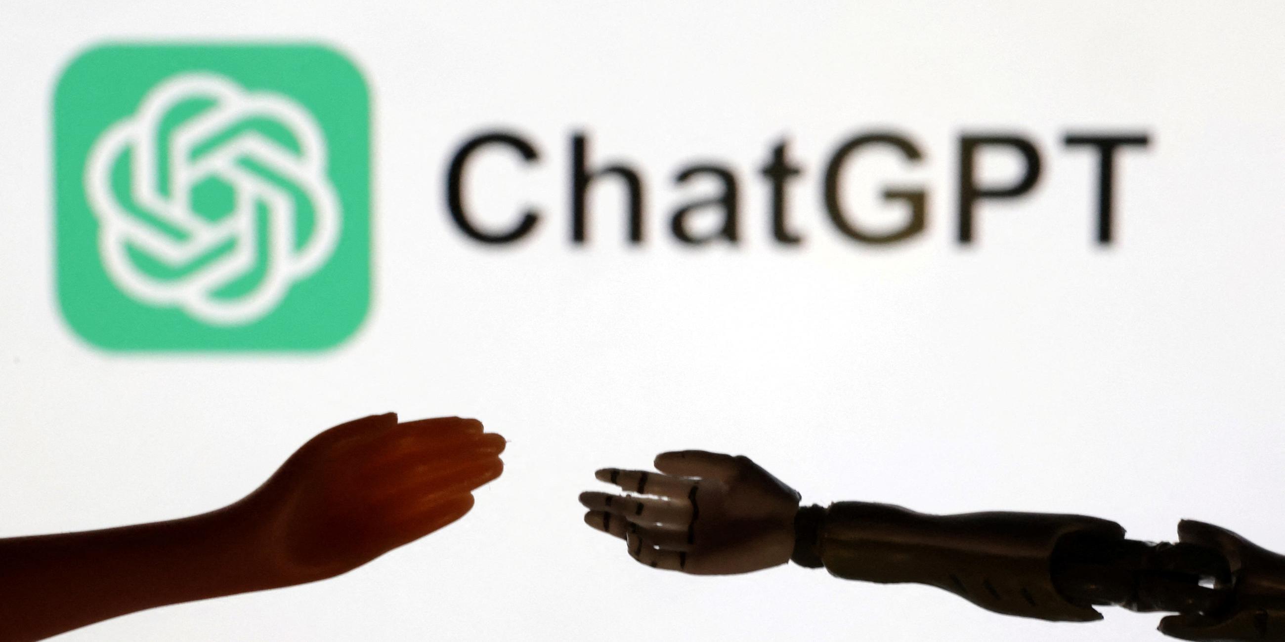 Eine Hand und eine Roboterhand vor dem ChatGPT-Logo