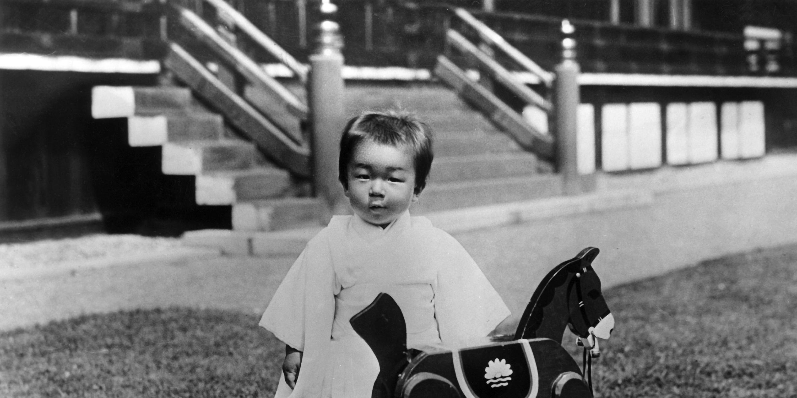 Prinz Akihito von Japan mit seinem Schaukelpferd im Garten des kaiserlichen Palasts (Undatiertes Archivbild 1930er)