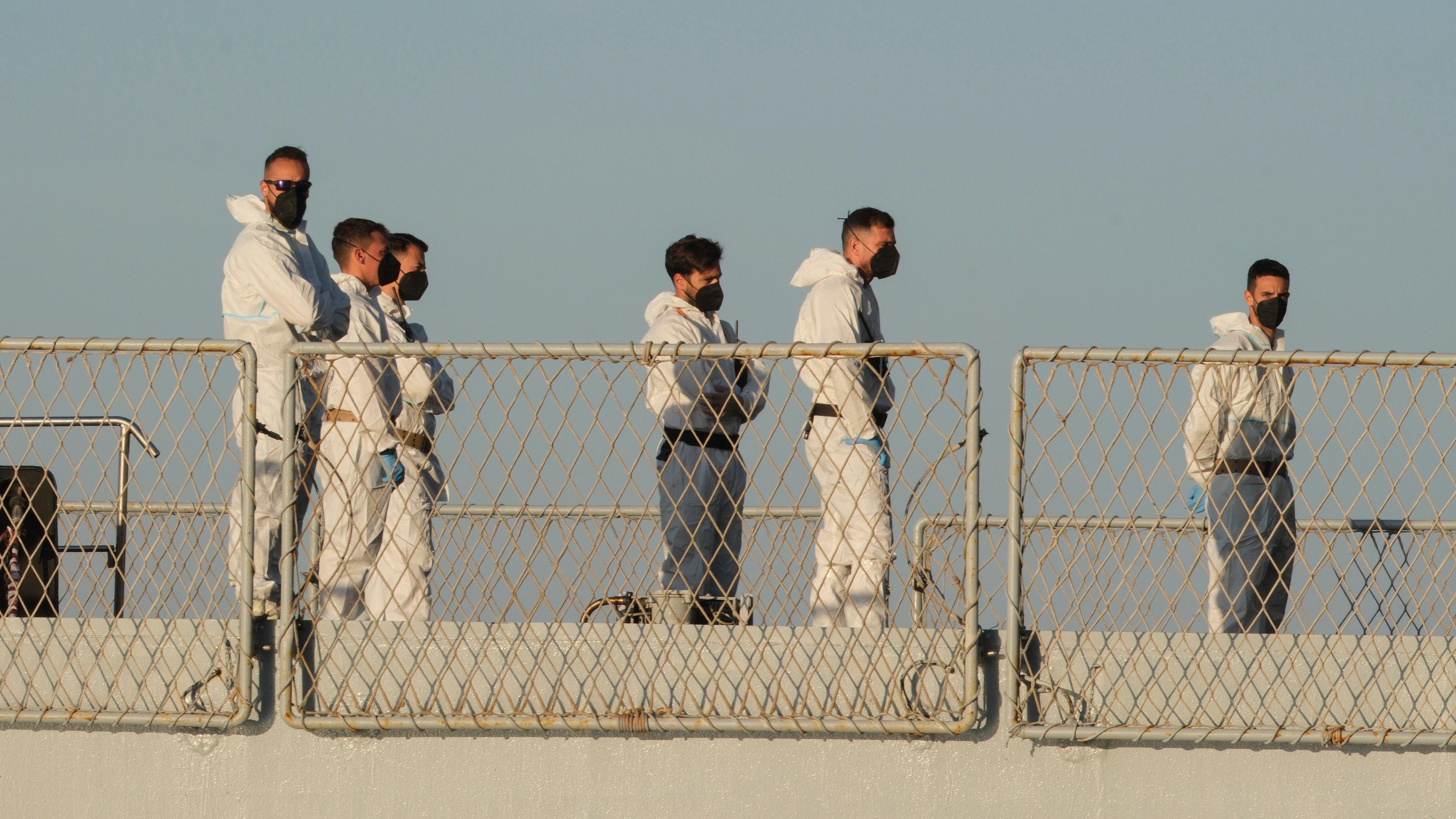 Security official stand on the Italian navy ship Libra as it arrives at the port of Shengjin, northwestern Albania