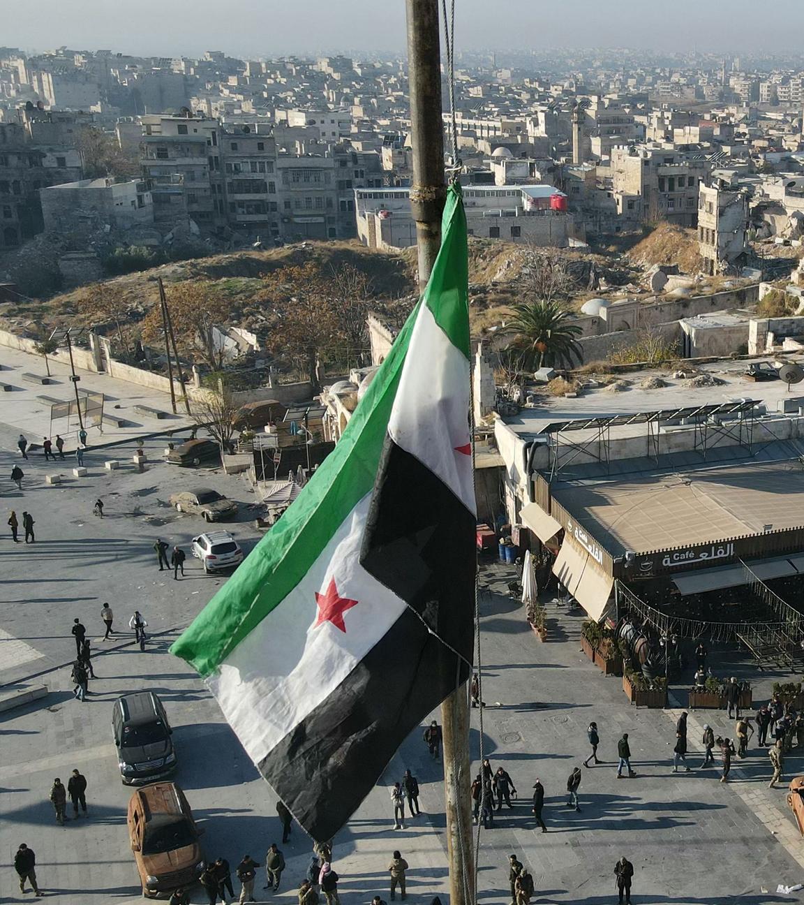 This aerial view shows a Syrian opposition flag flying above a market square in central Aleppo on November 30, 2024. 