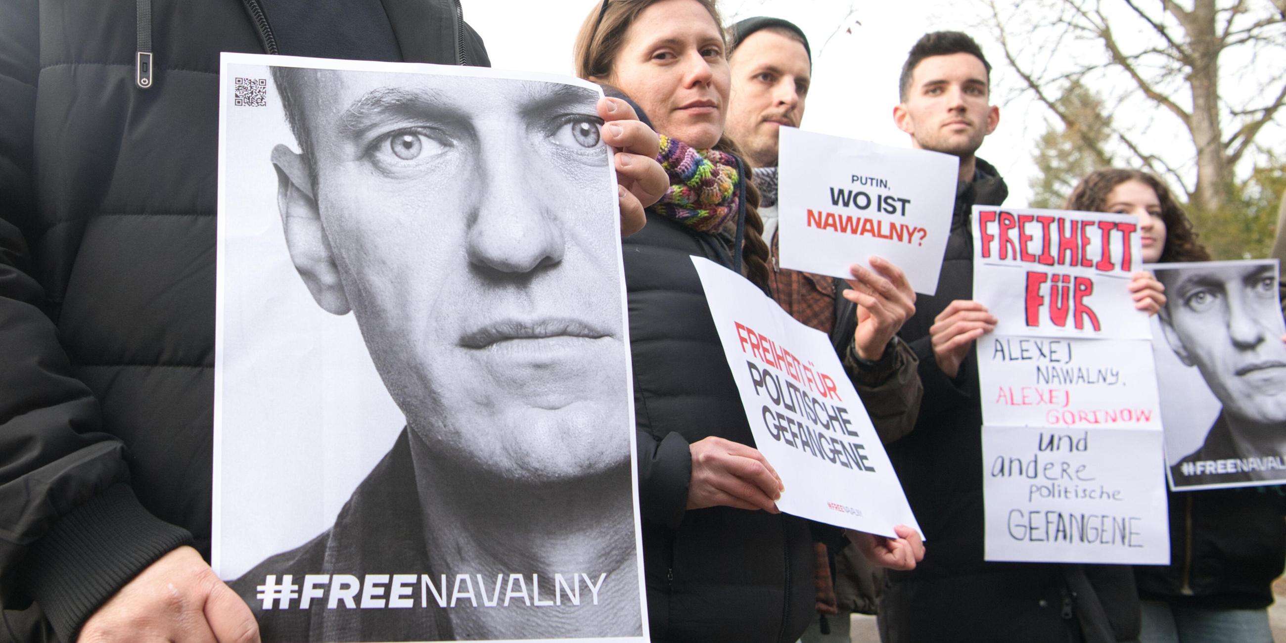 Demonstranten halten Plakate für die Freilassung von Alexej Nwalny in die Höhe.