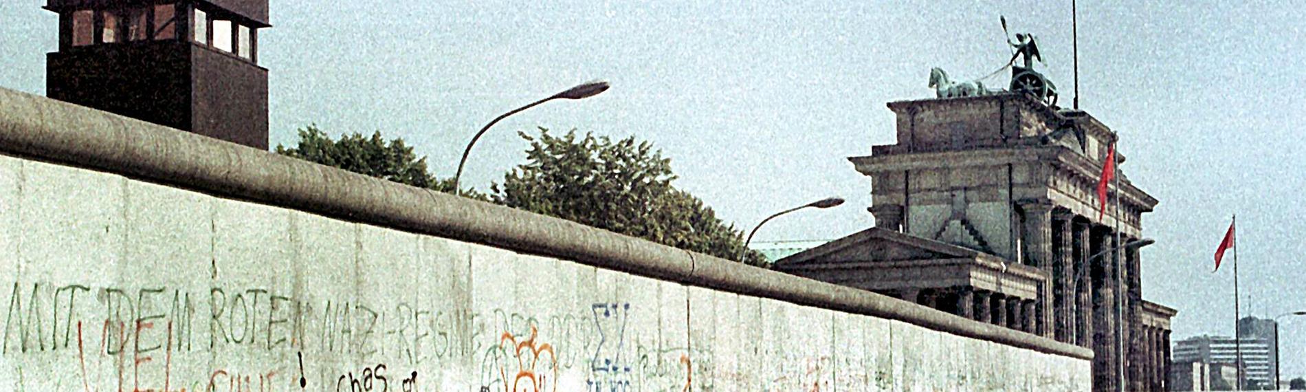 Das Archivbild vom August 1984 zeigt die Berliner Mauer mit einem Wachturm (l) am Brandenburger Tor (r).