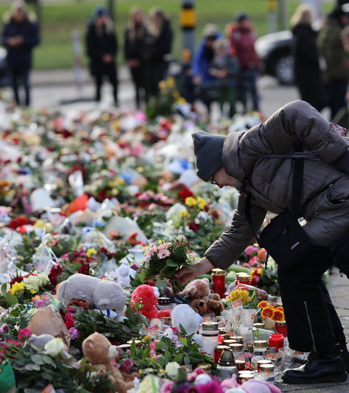 Sachsen-Anhalt, Magdeburg: Trauernde stehen vor der Johanniskirche, dem zentralen Gedenkort nach dem Anschlag auf dem Magdeburger Weihnachtsmarkt, und legen Blumen ab.