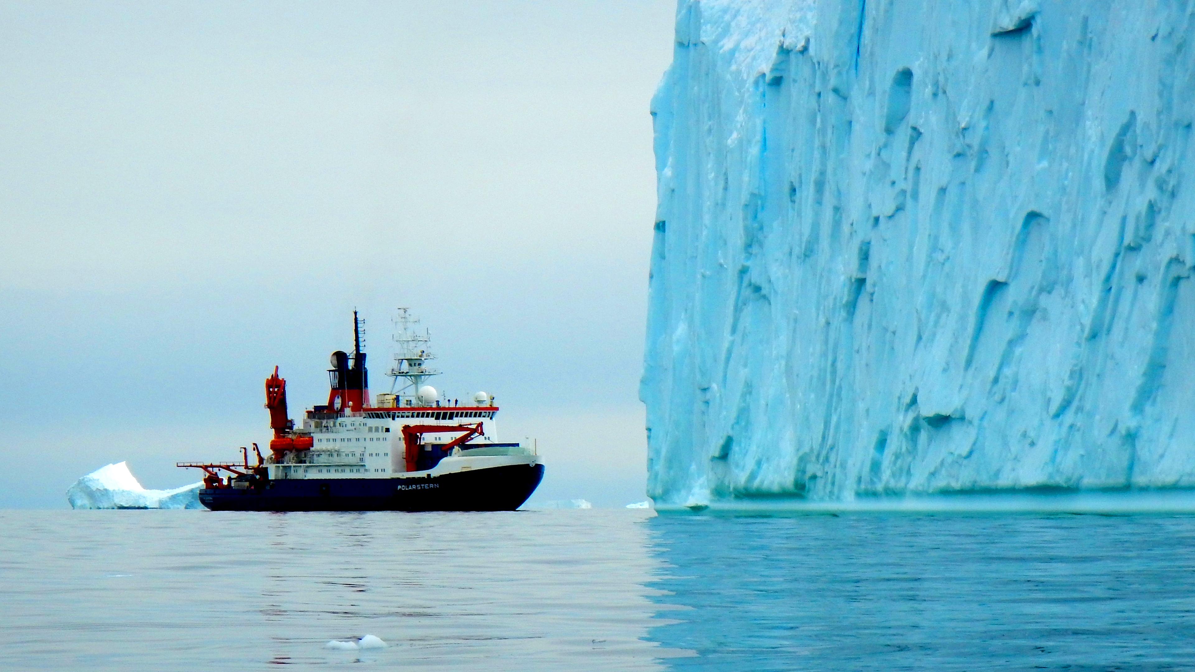 Ein Expeditionsschiff fährt an einem riesigen Gletscher vorbei.