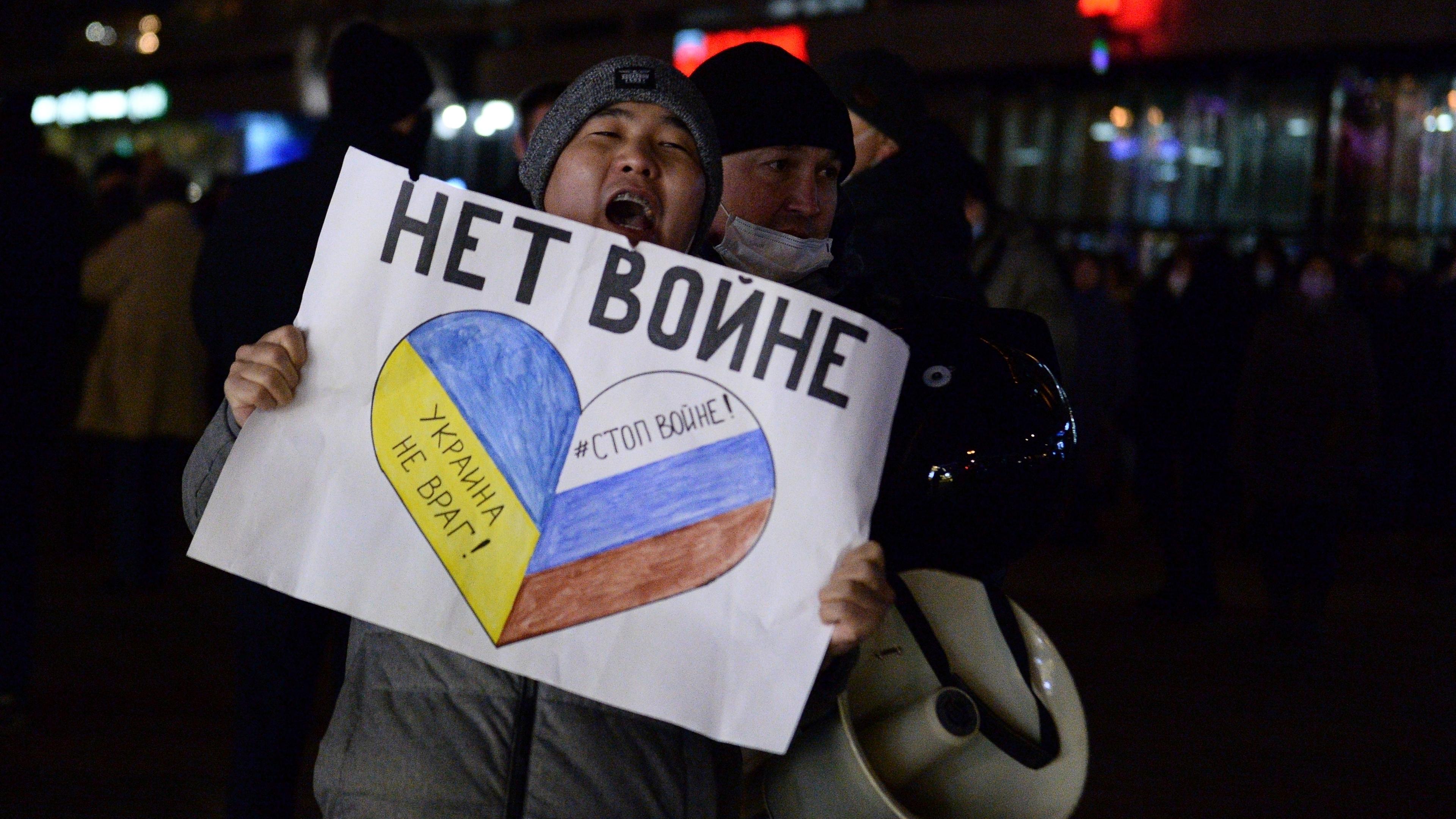 Polizisten nehmen einen Demonstranten mit dem Plakat „Kein Krieg“ während einer Aktion gegen Russlands Angriff auf die Ukraine in Moskau