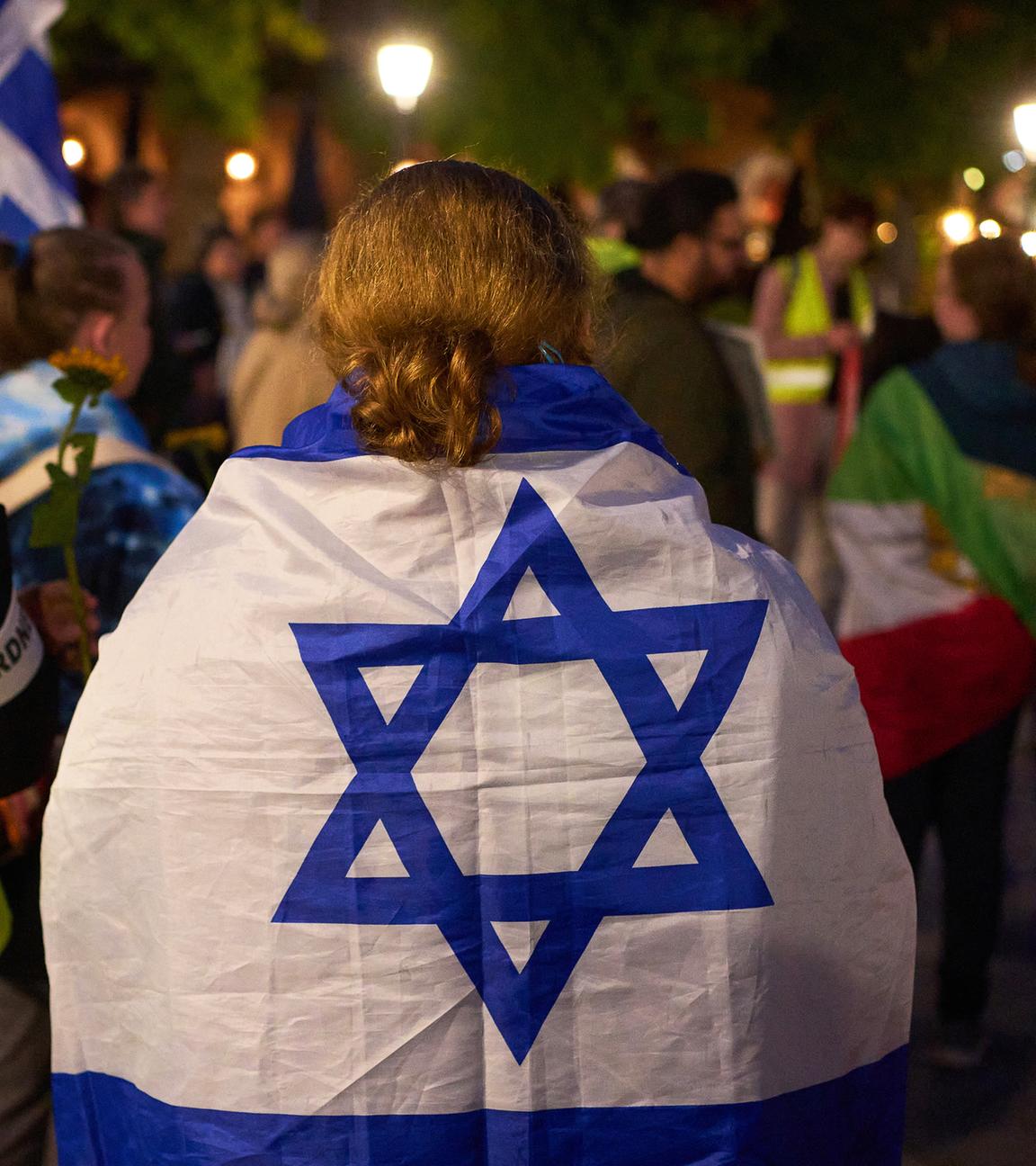 Rheinland-Pfalz, Koblenz: Eine Teilnehmerin einer Demonstration gegen Antisemitismus trägt am Jahrestag des Hamas-Angriffes auf Israel eine israelische Flagge.