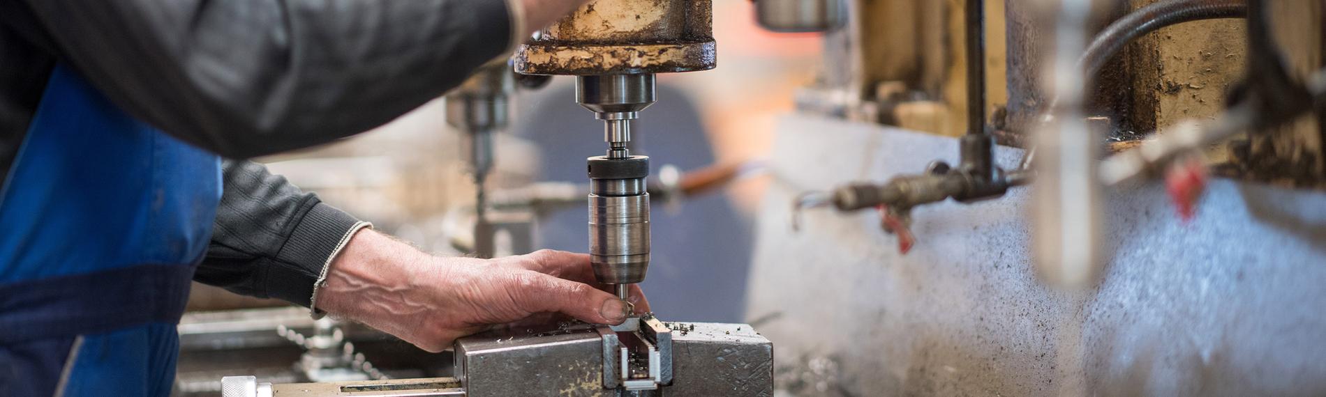 Ein Mitarbeiter bedient eine Maschine zur Verarbeitung von Metall in Brandenburg am 02.11.2018