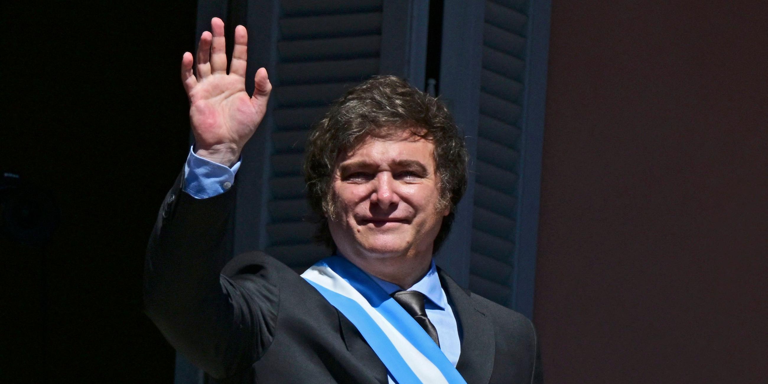 Argentiniens neuer Präsident Javier Milei winkt der Menge von einem Balkon der Casa Rosada-Regierung zu.