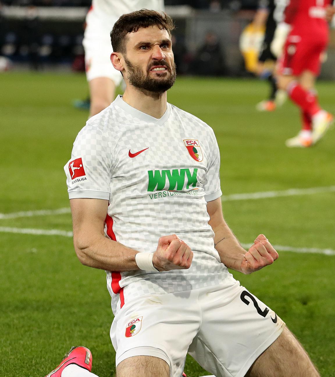 Augsburgs Torschütze Daniel Caligiuri (M, unten) feiert seinen Treffer zum 0:1 am 04.03.2022 in Bielefeld.