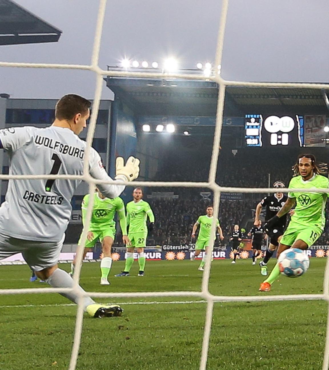 20.11.2021, Nordrhein-Westfalen, Bielefeld: Fußball: Bundesliga, Arminia Bielefeld - VfL Wolfsburg, 12. Spieltag in der Schüco-Arena. Bielefelds Torschütze Masaya Okugawa (l) erzielt den Treffer zum 1:0 gegen Wolfsburgs Torwart Koen Casteels (vorne).