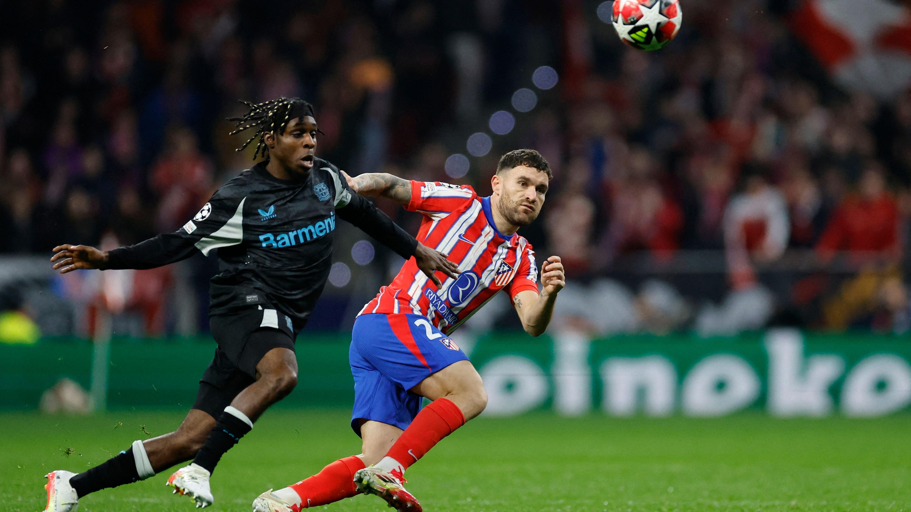 Leverkusens Jeremie Frimpong (l.) und Atletico Madrids Javi Galan kämpfen um den Ball.