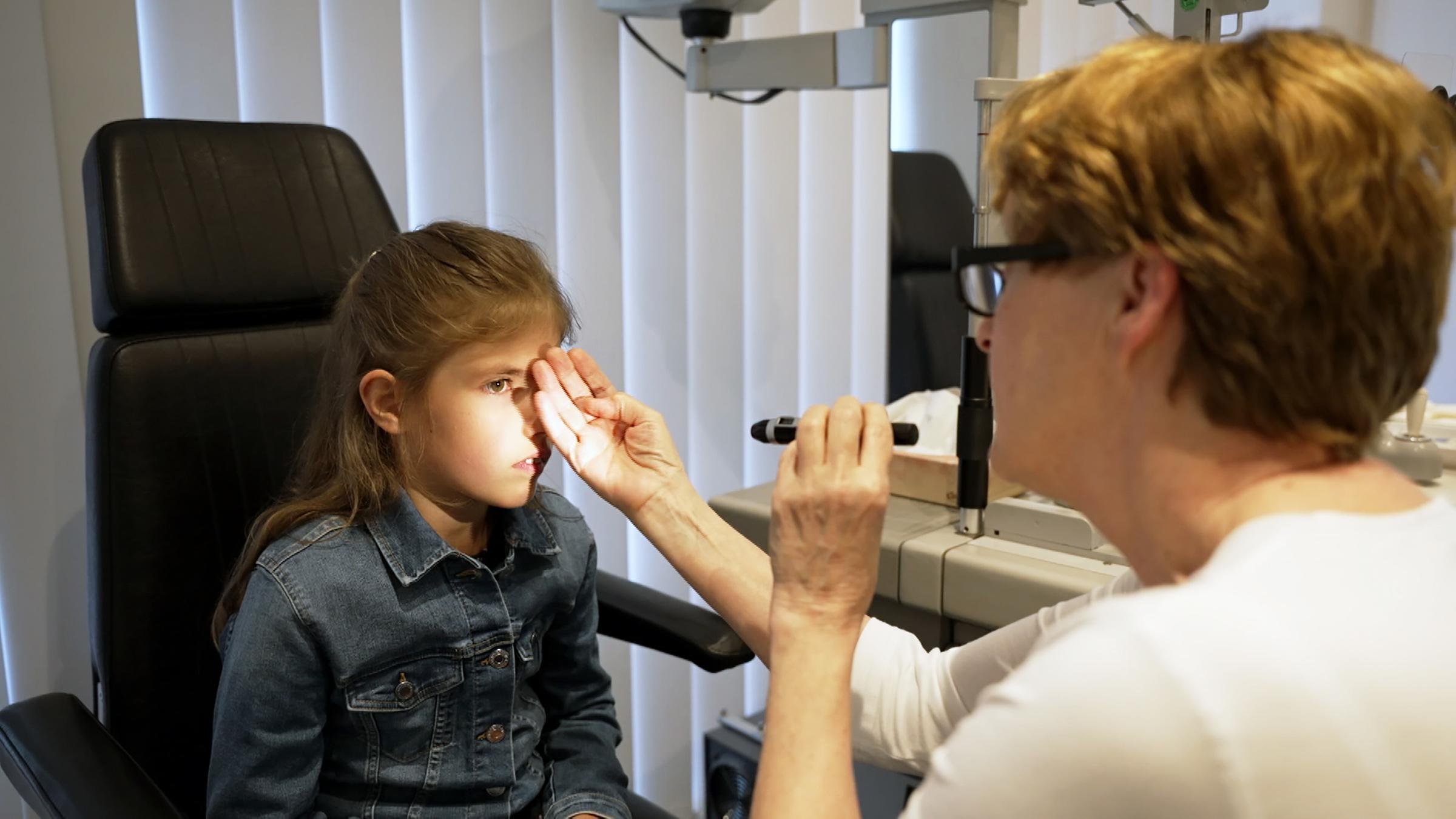 Mädchen wird von Augenärztin untersucht